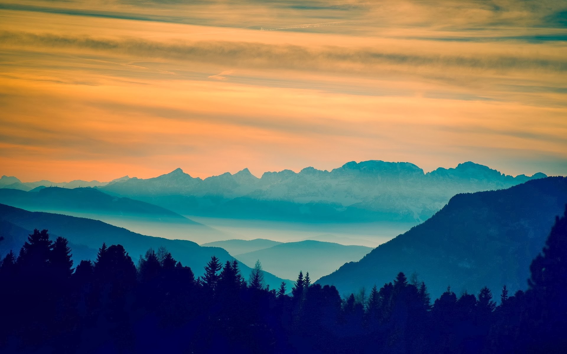 Mountain range at sunset with orange sky HD Wallpaper