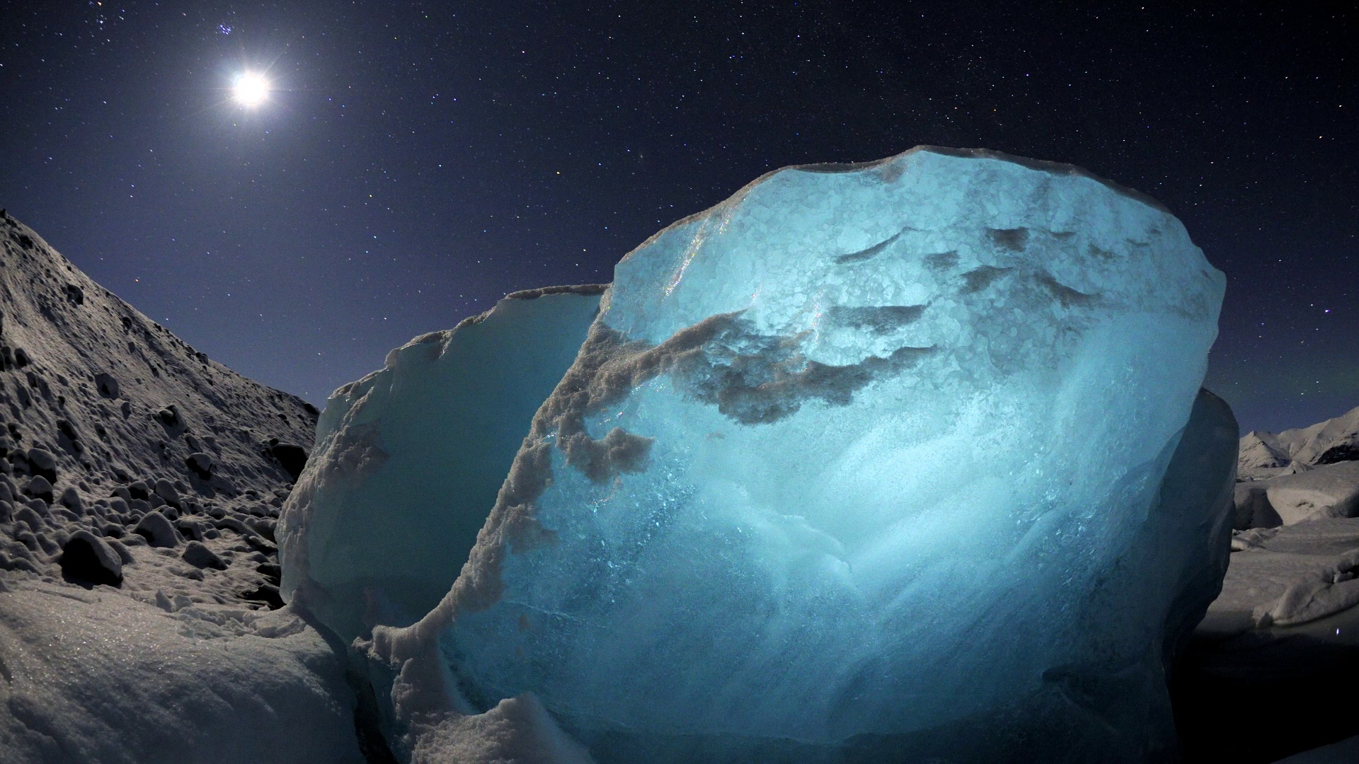 Blue ice formation under starry night sky HD Wallpaper