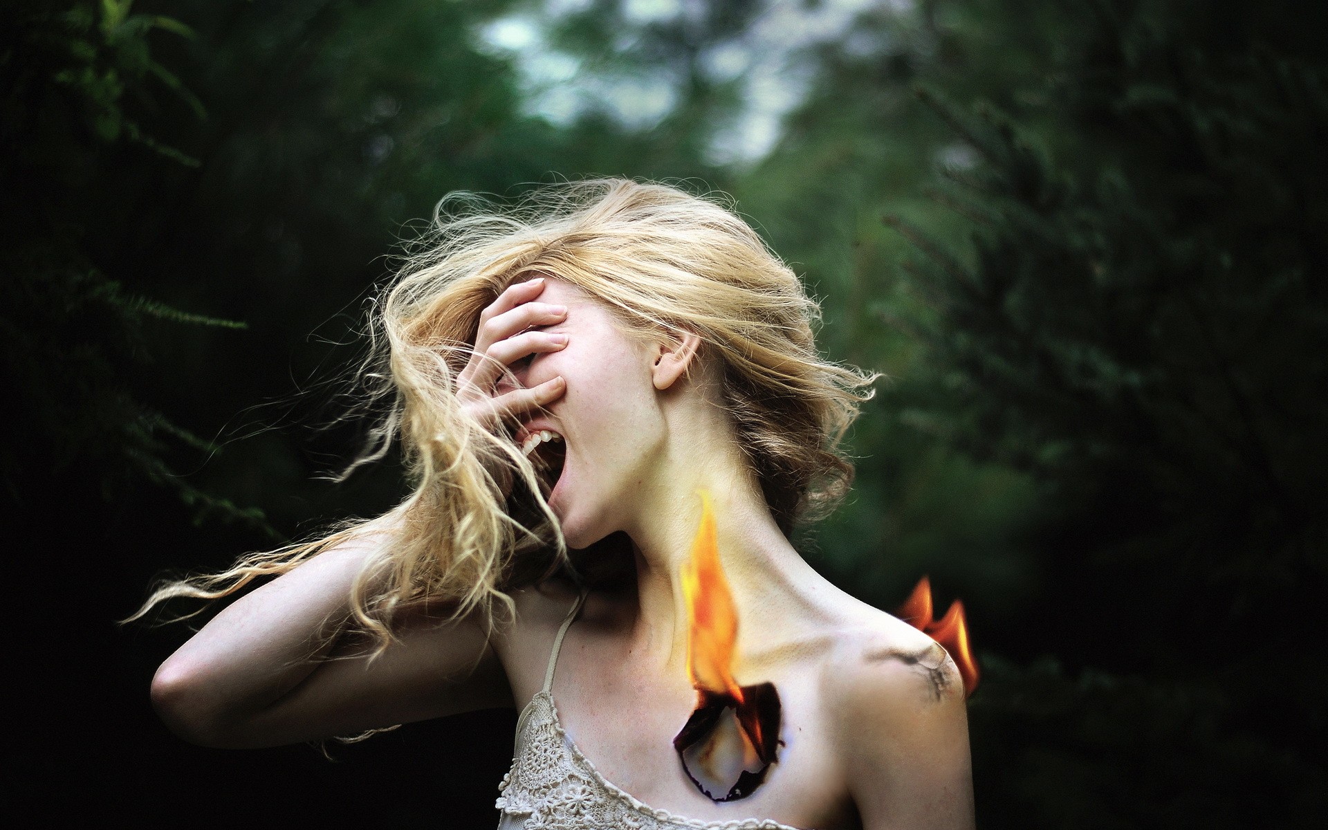 Woman with fire on her chest screaming outdoors HD Wallpaper