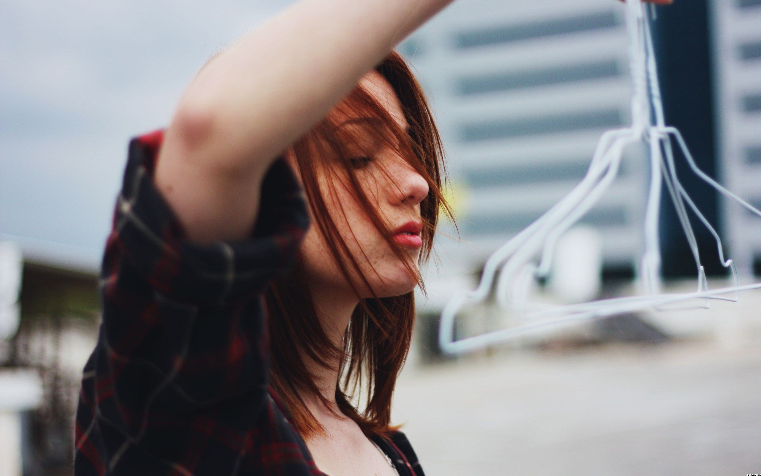 Redhead woman with eyes closed holding hangers HD Wallpaper