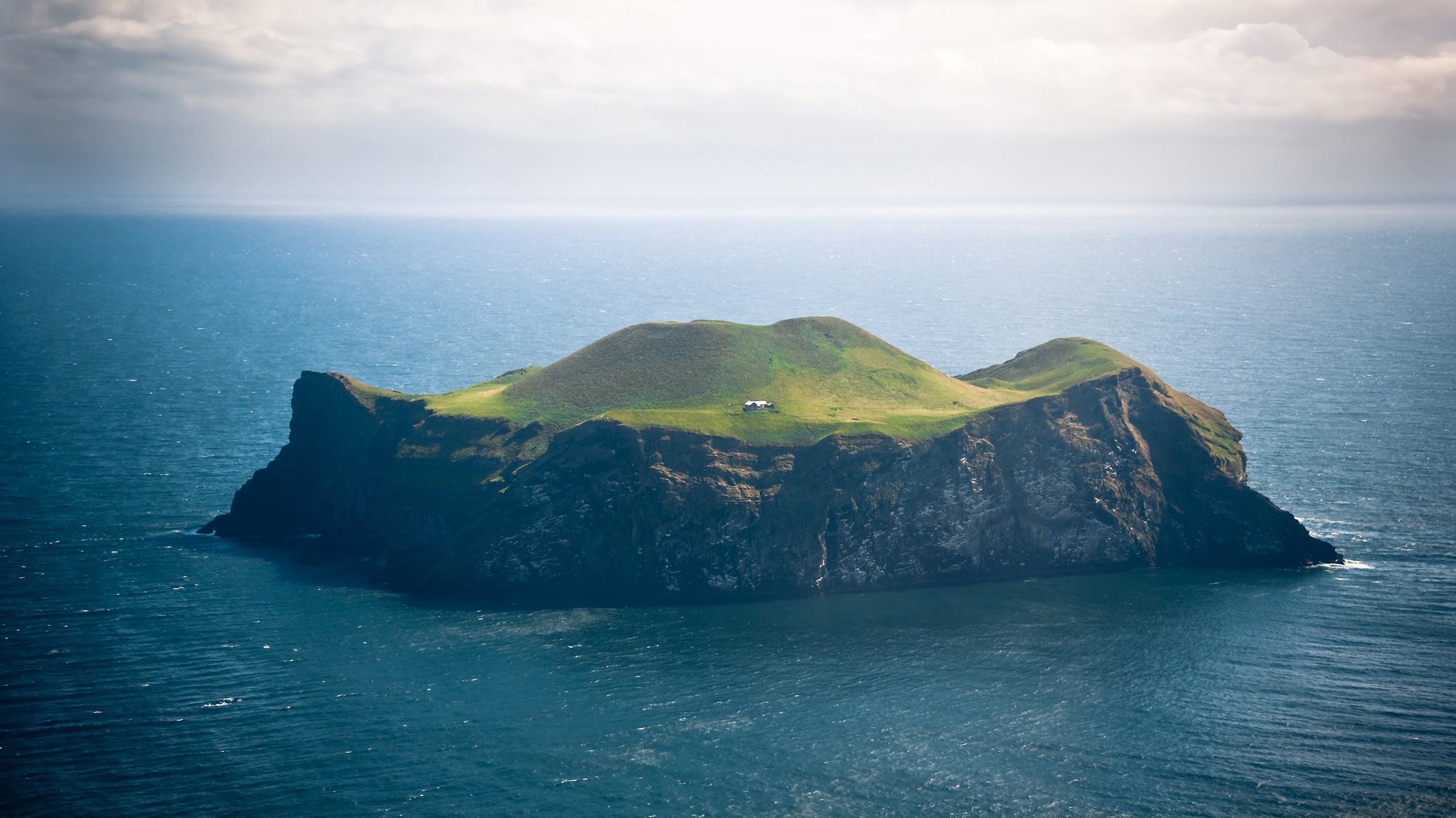 A small house on a grassy island in Vestmannaeyjar, Iceland HD Wallpaper