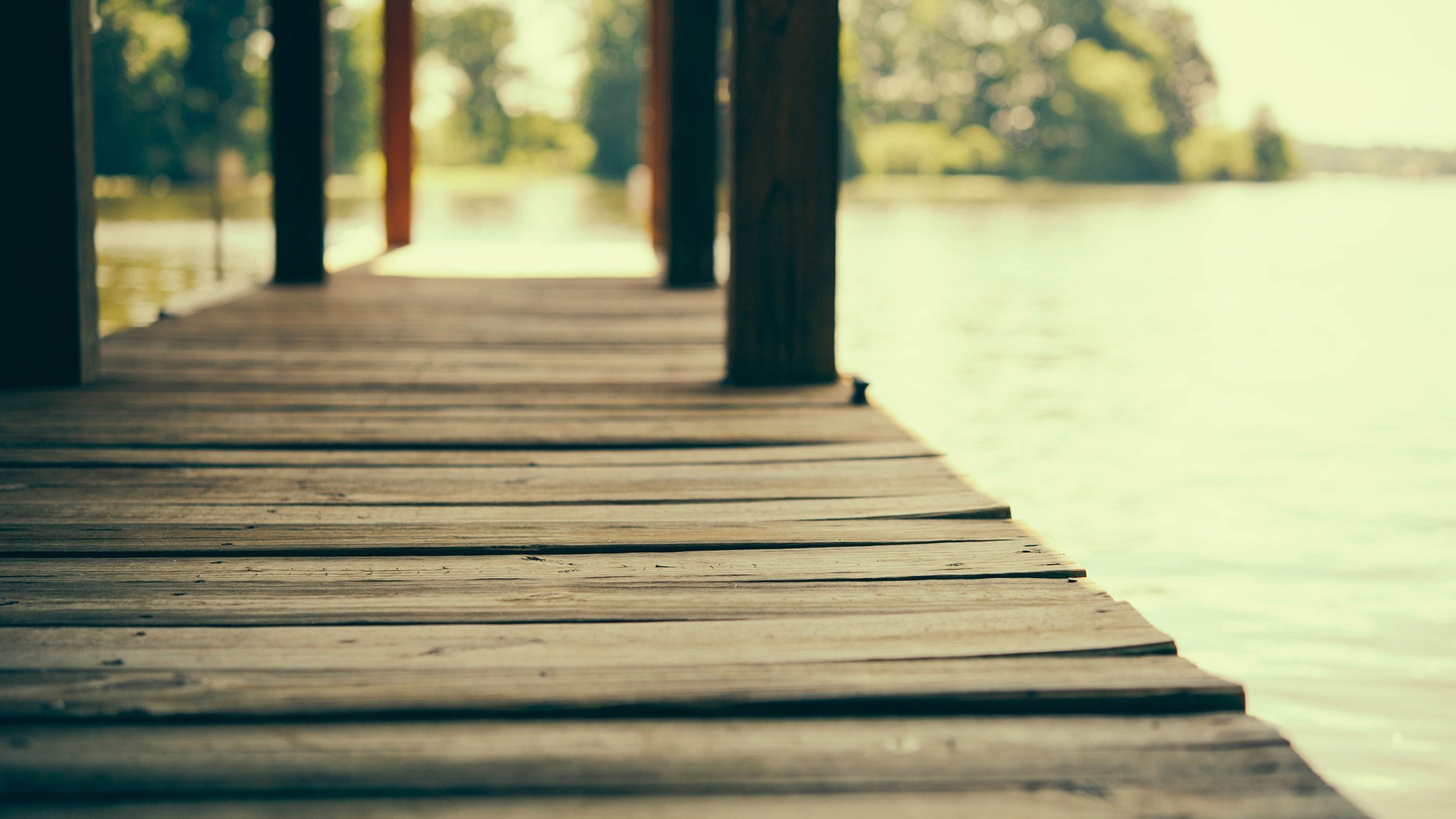 Wooden pier on a lake with trees in the background HD Wallpaper