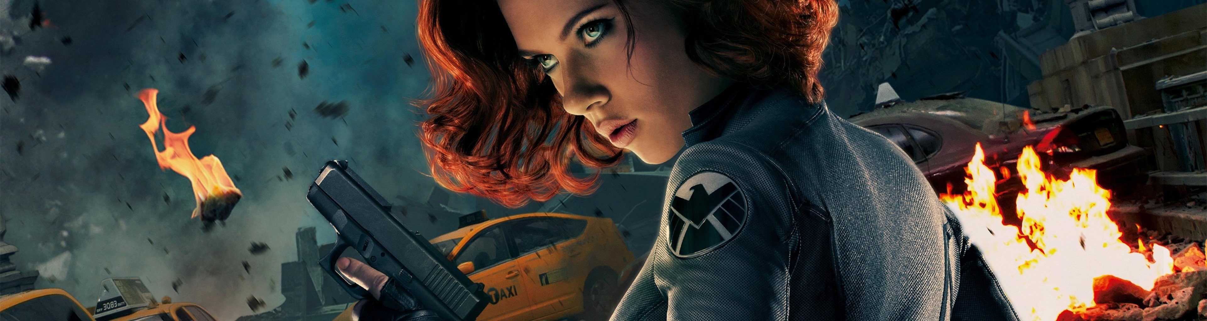 Black Widow holding a gun in a chaotic scene HD Wallpaper