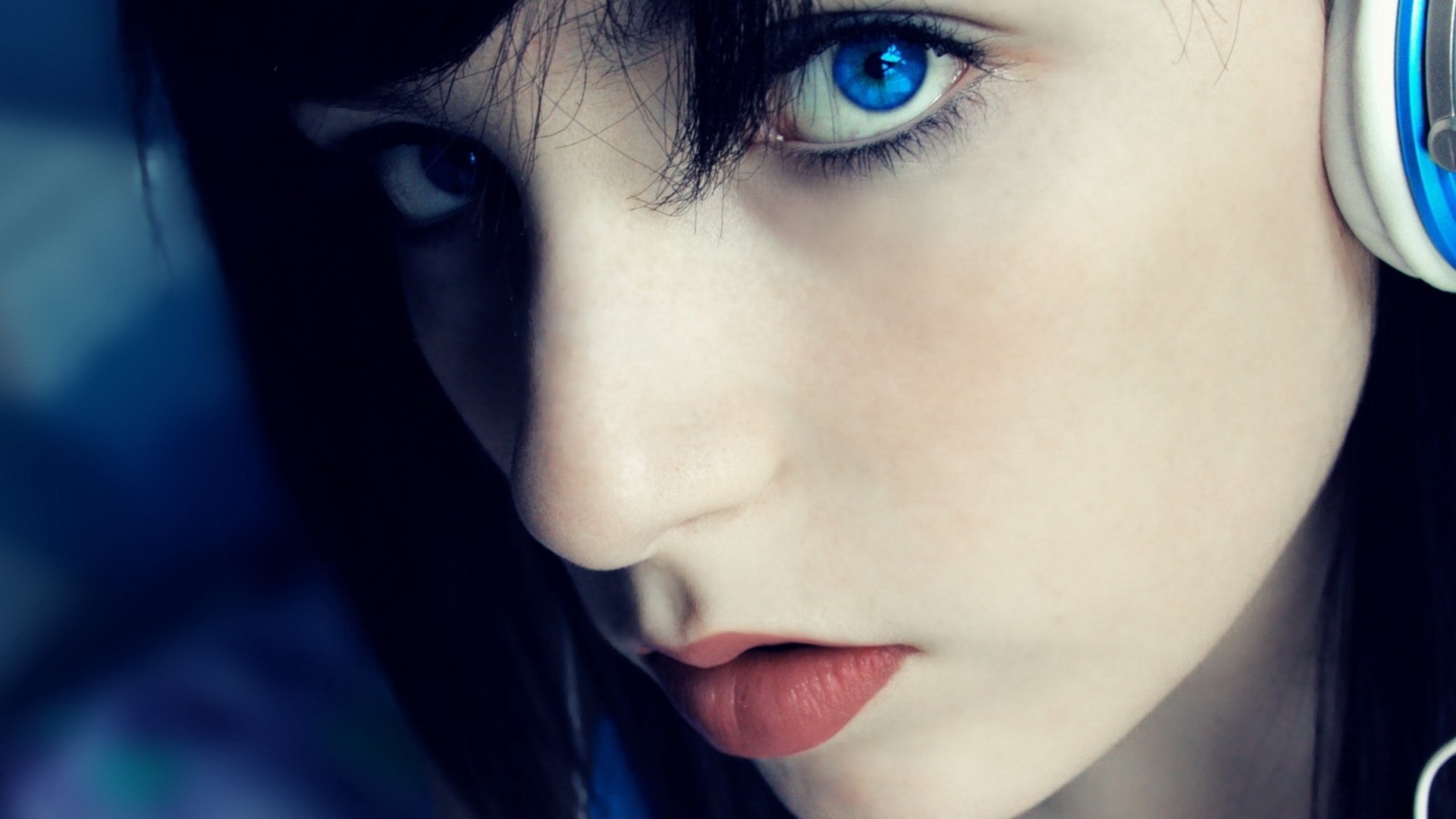 Woman with bright blue eyes wearing headphones HD Wallpaper