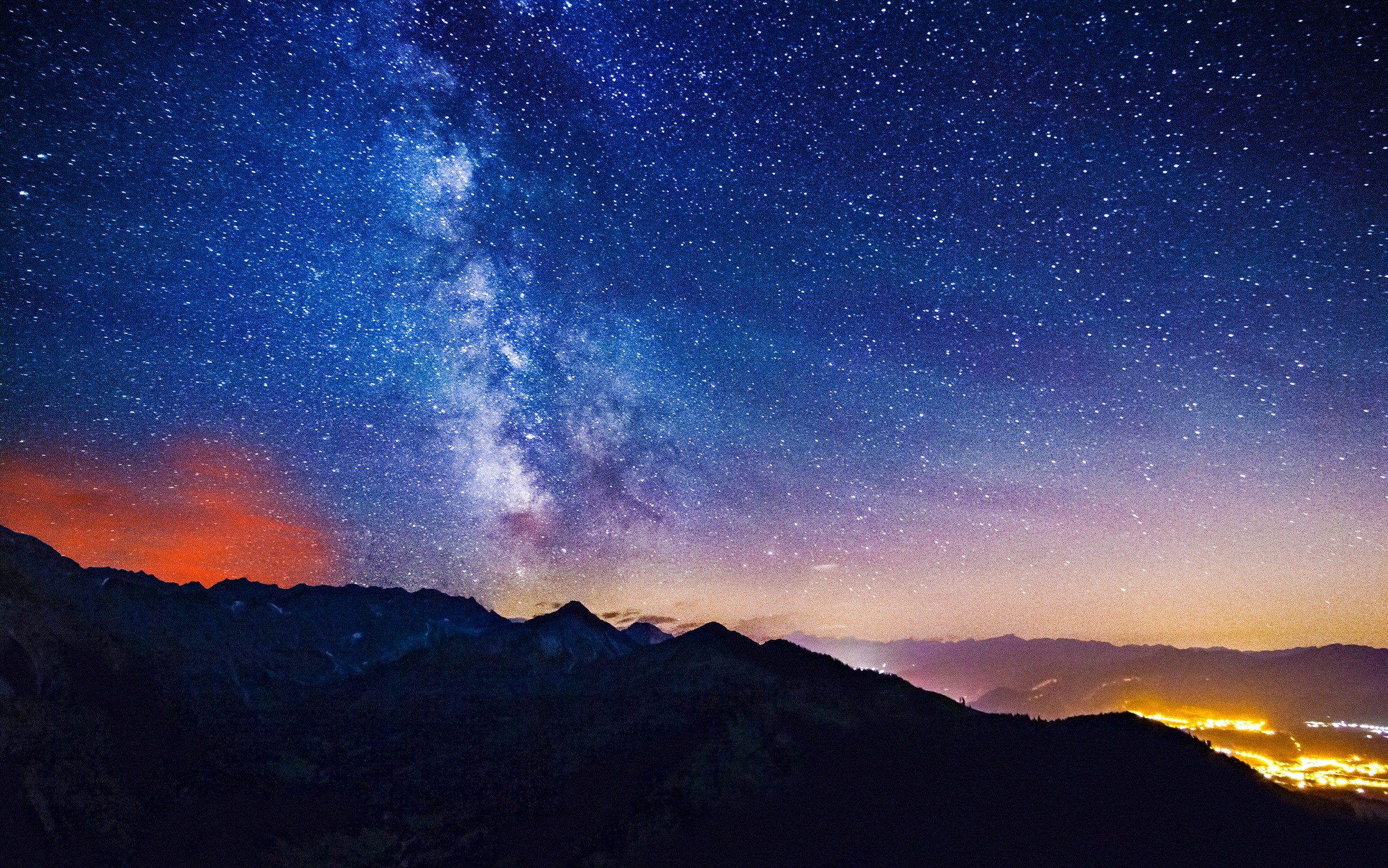 Milky Way over dark mountains and distant lights HD Wallpaper