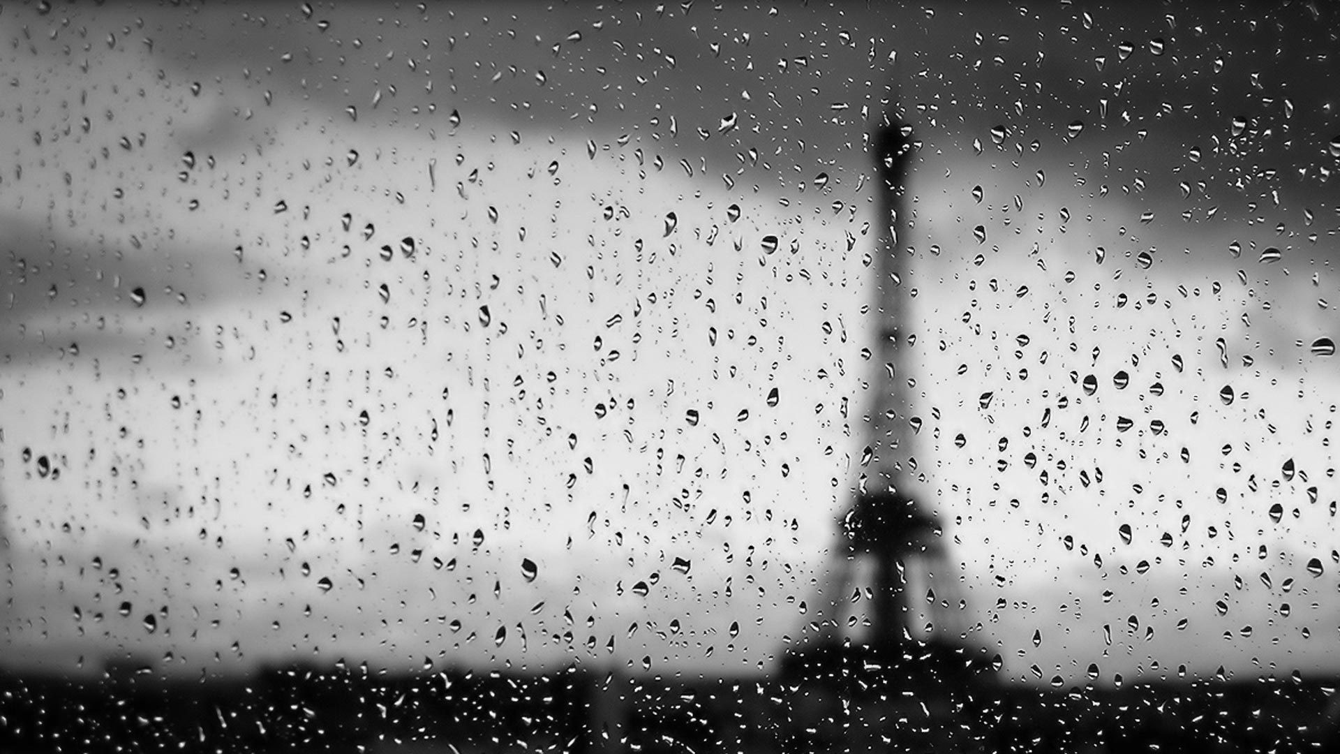 Eiffel Tower through raindrops on glass HD Wallpaper