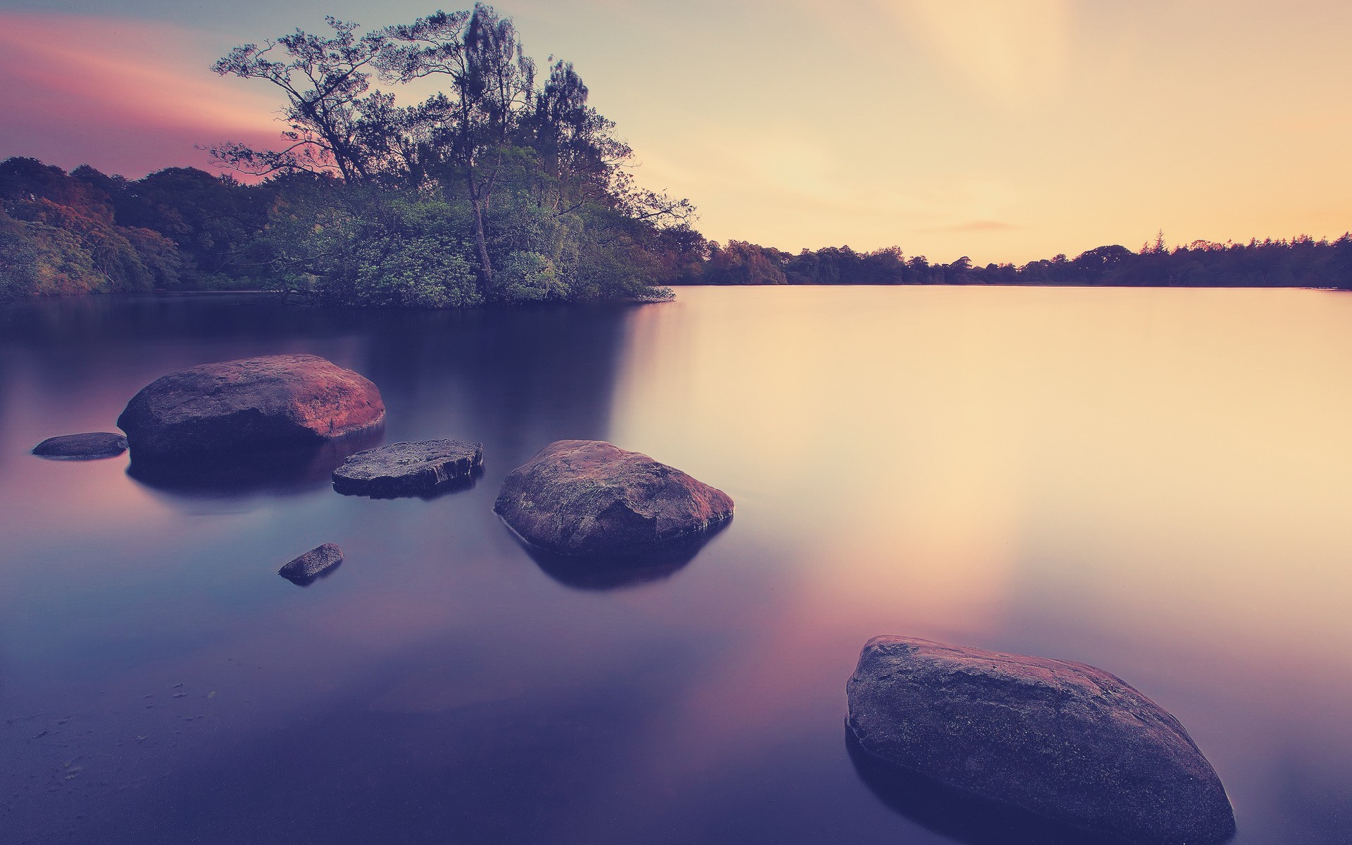 Rocks in a lake at sunset HD Wallpaper