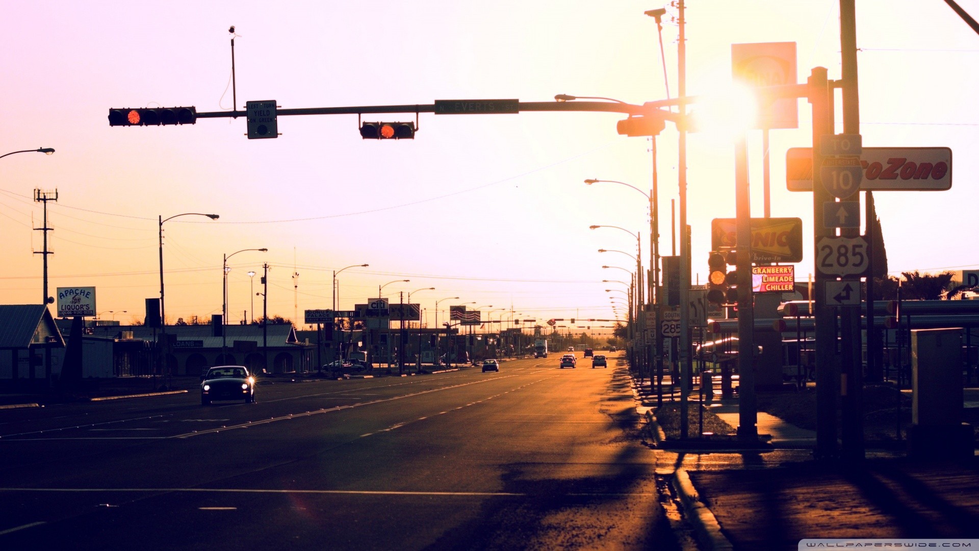 Road with traffic lights and signs at sunset HD Wallpaper