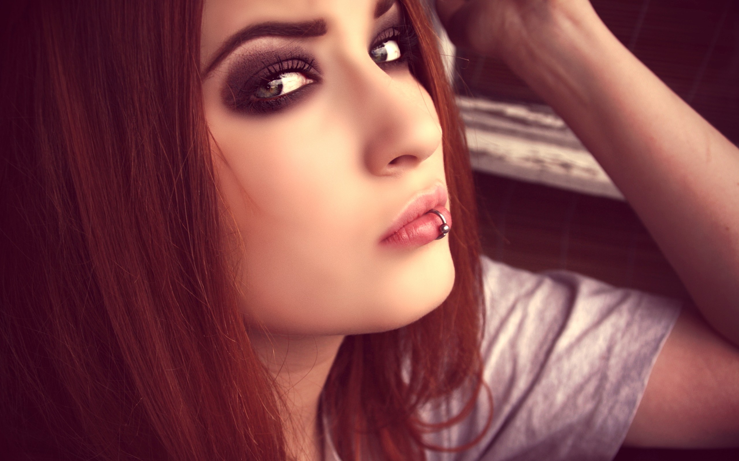 Redhead woman with pierced lips and smoky eye makeup HD Wallpaper