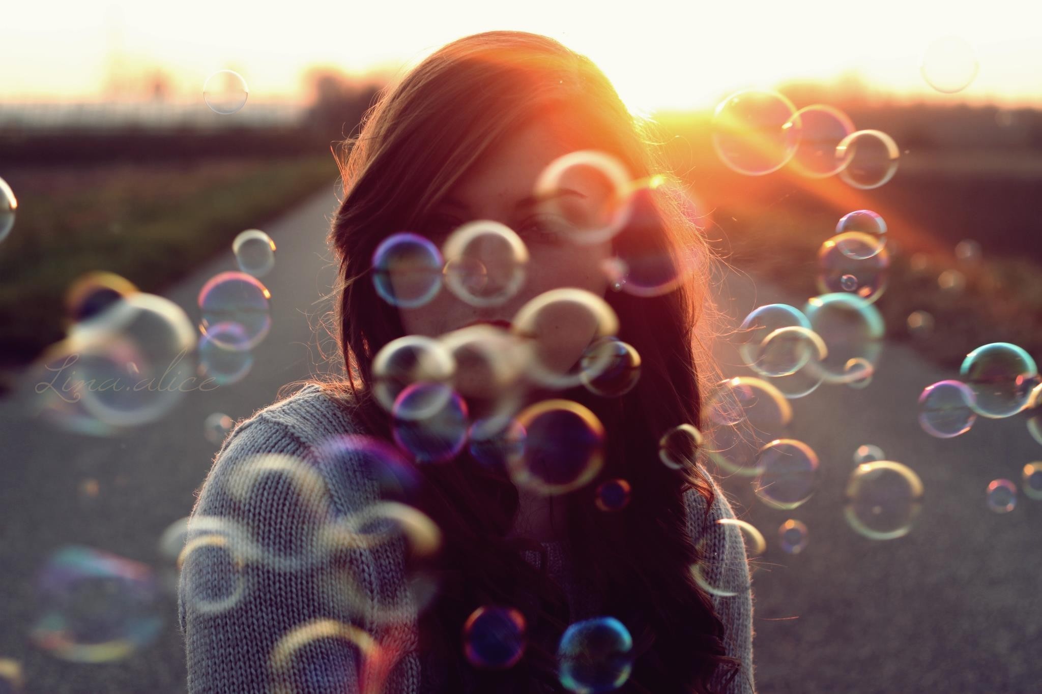 Woman blowing bubbles at sunset HD Wallpaper