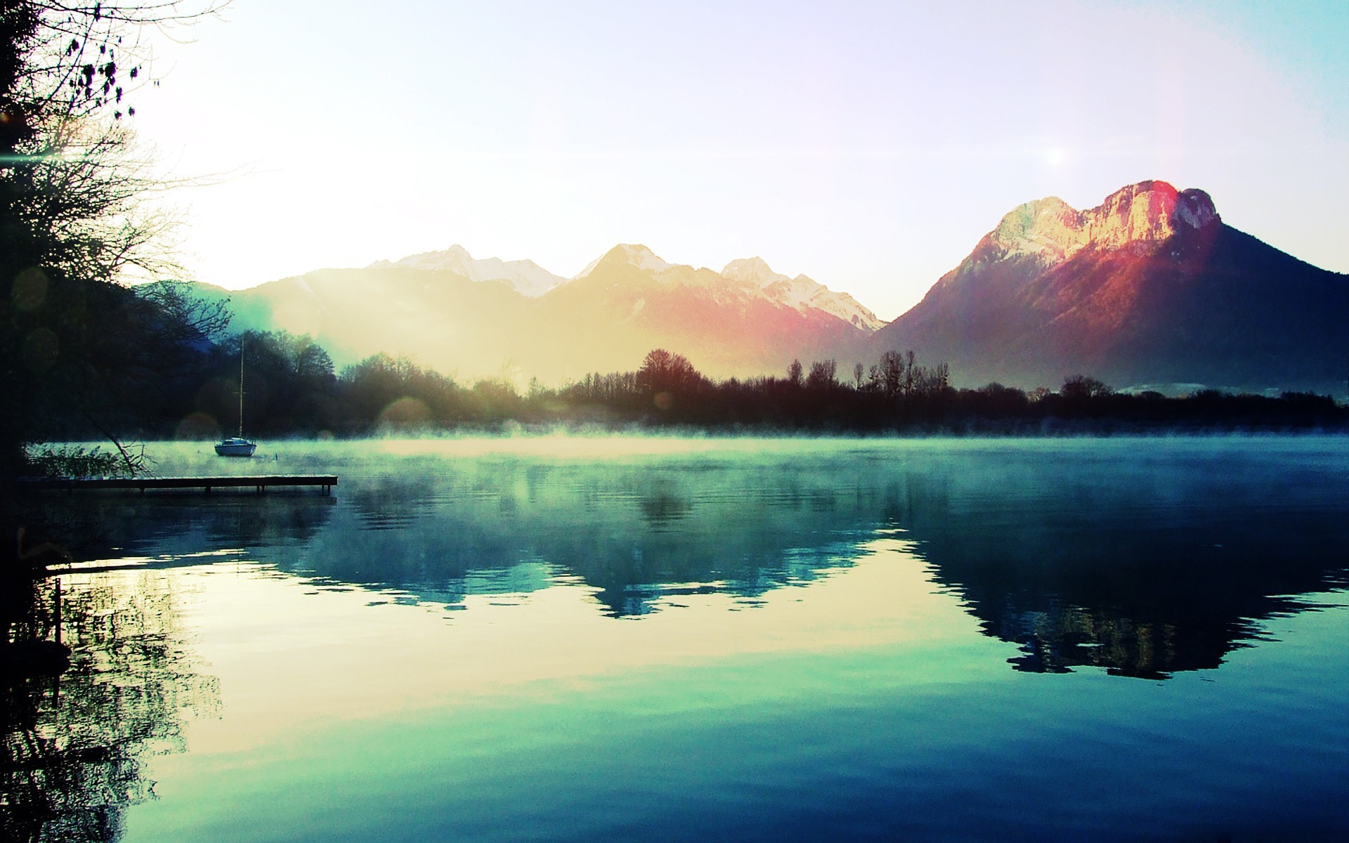 Boat on a misty lake with mountains in the background HD Wallpaper