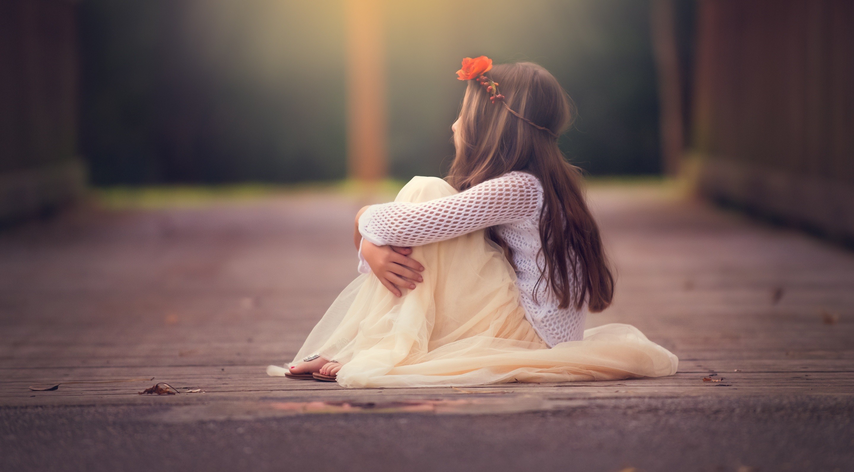 A young girl sitting on a wooden path HD Wallpaper