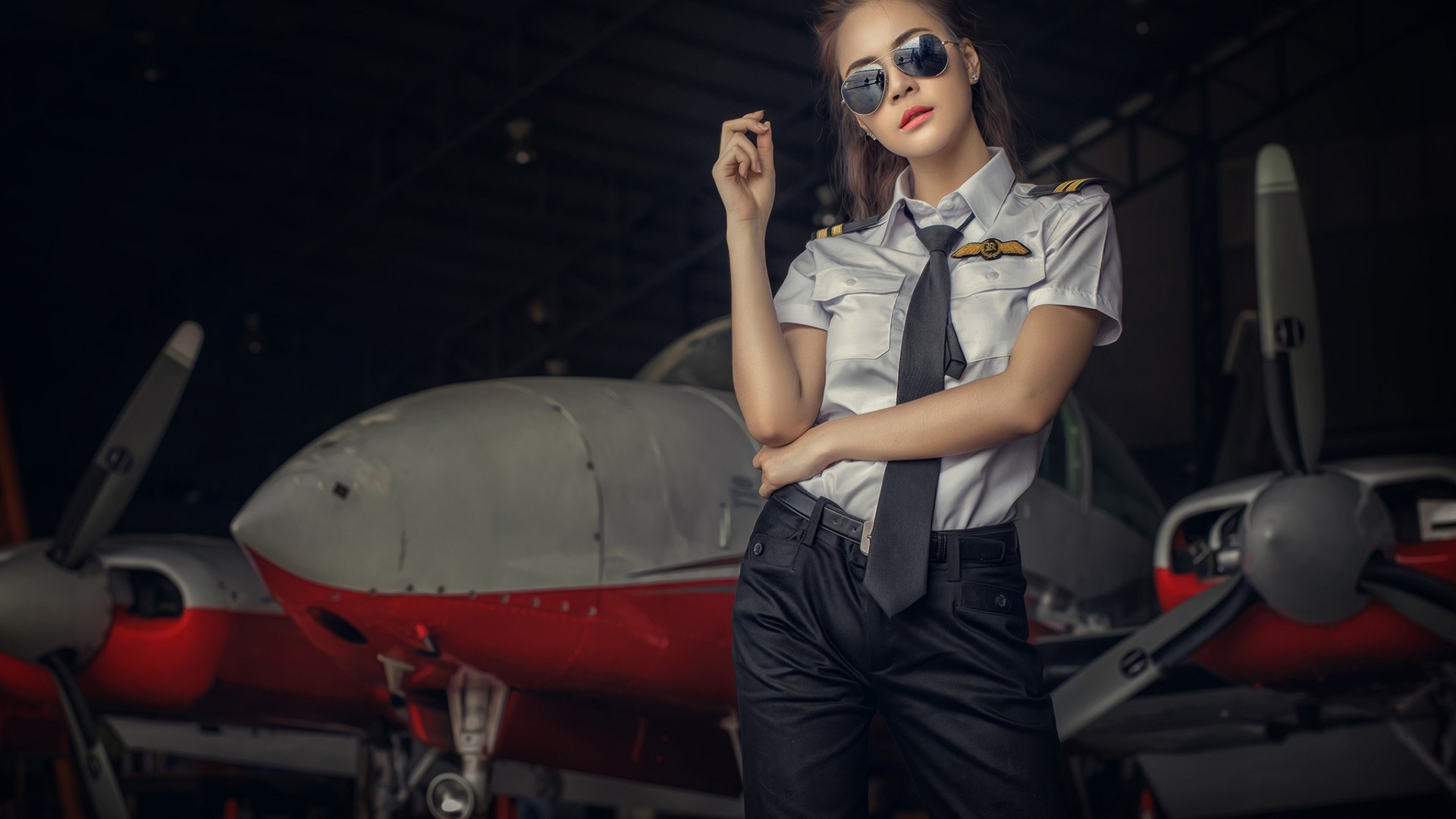 Woman in pilot uniform posing near an aircraft HD Wallpaper
