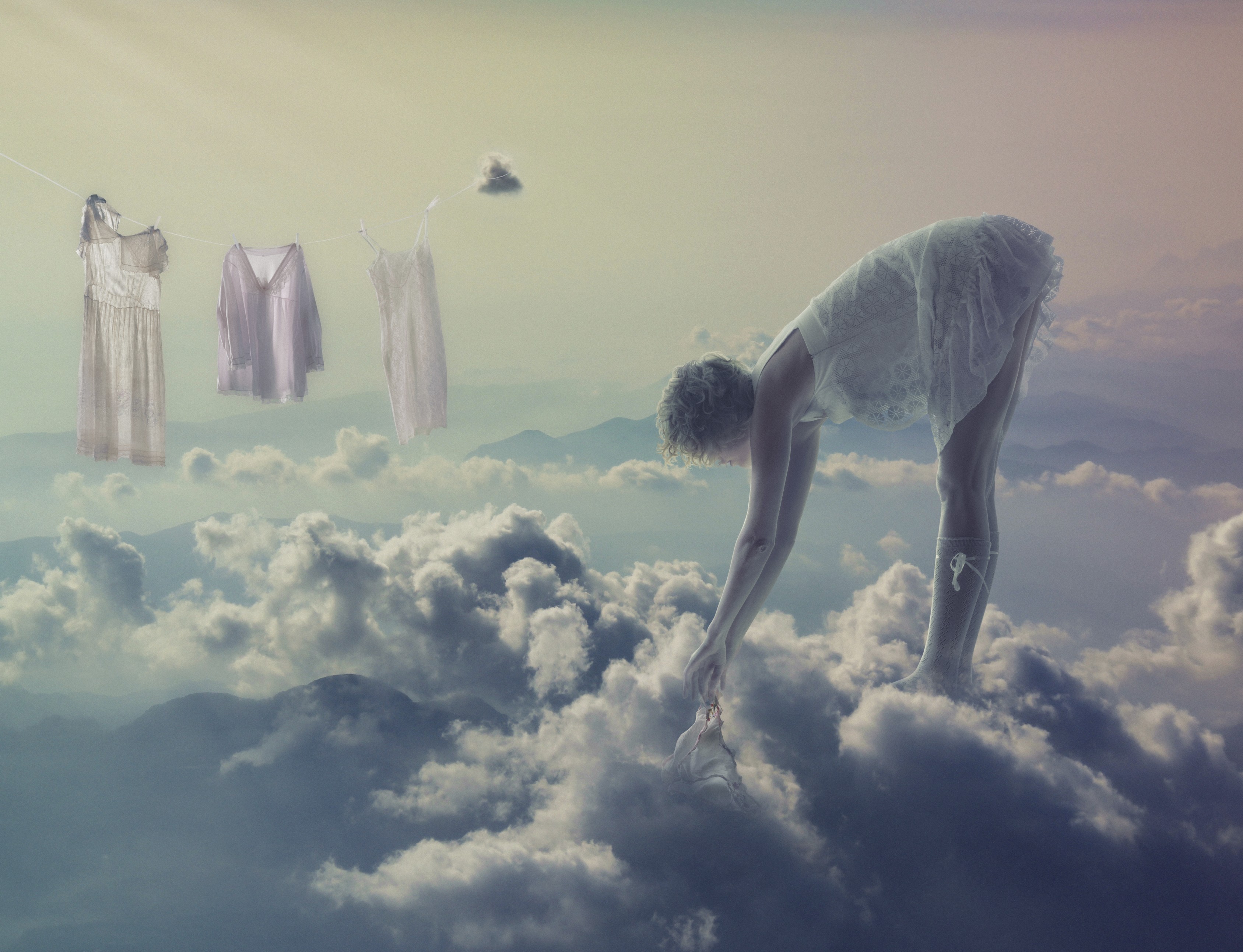 Woman in white dress bending over in clouds HD Wallpaper
