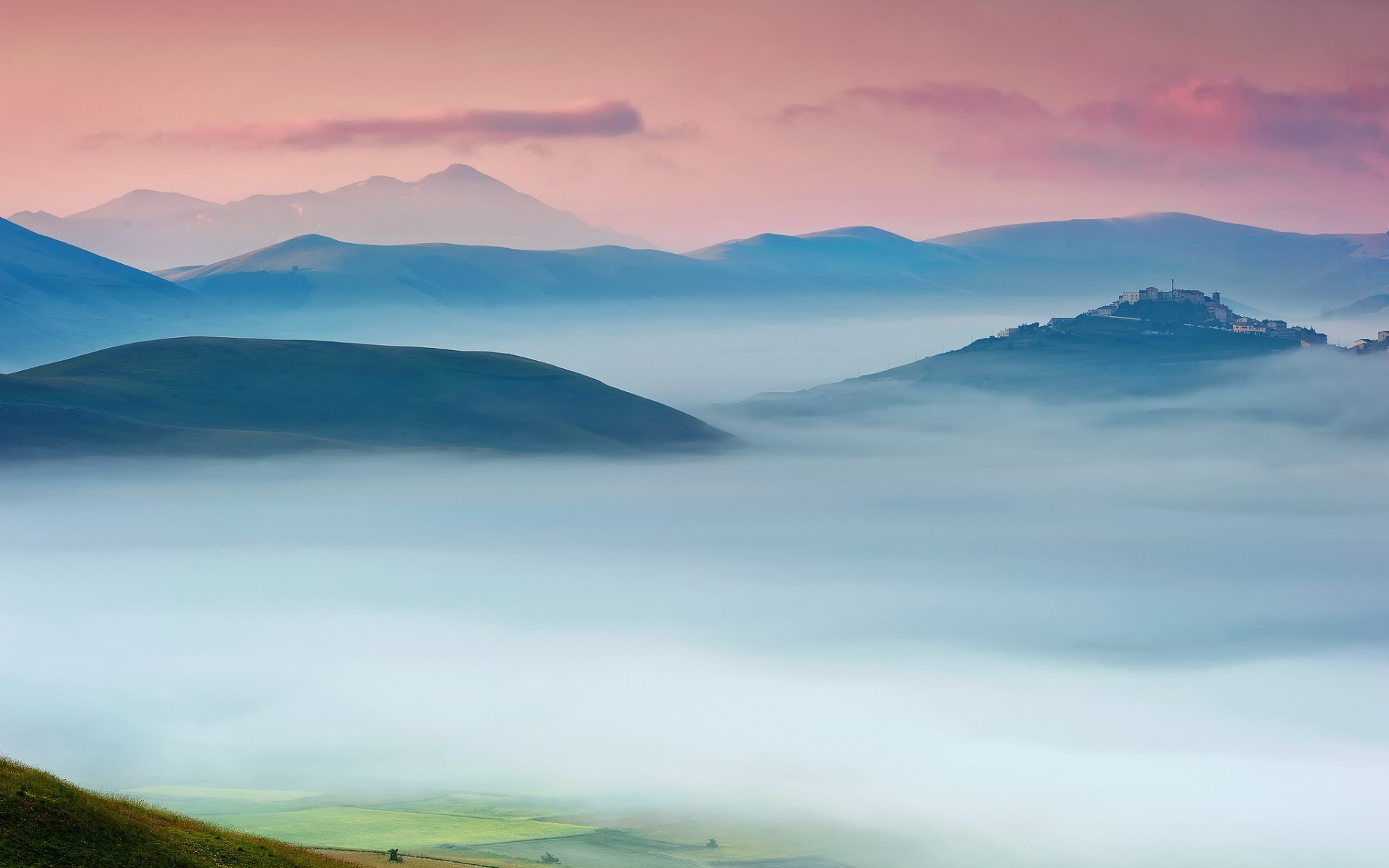 Misty mountain landscape with a village on a hill HD Wallpaper