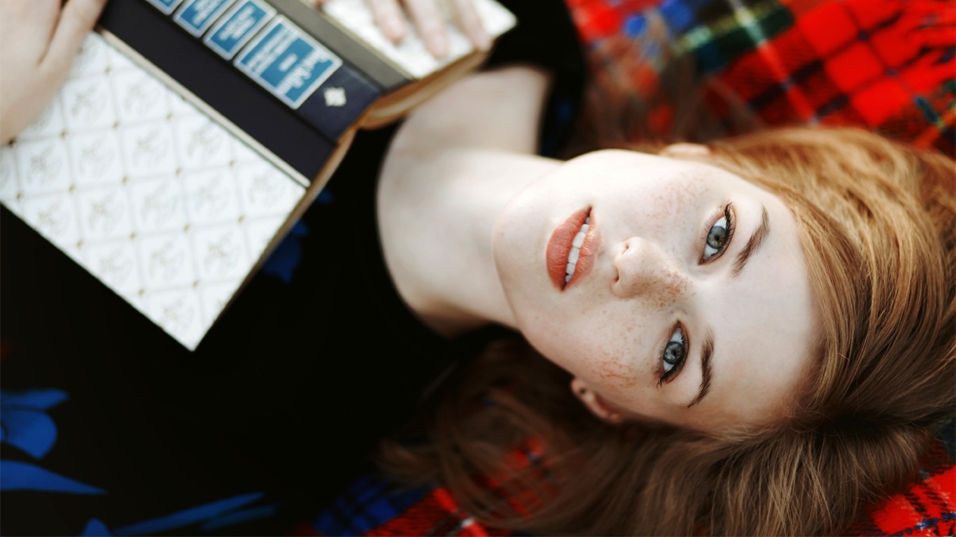 Redhead woman with freckles holding a book HD Wallpaper