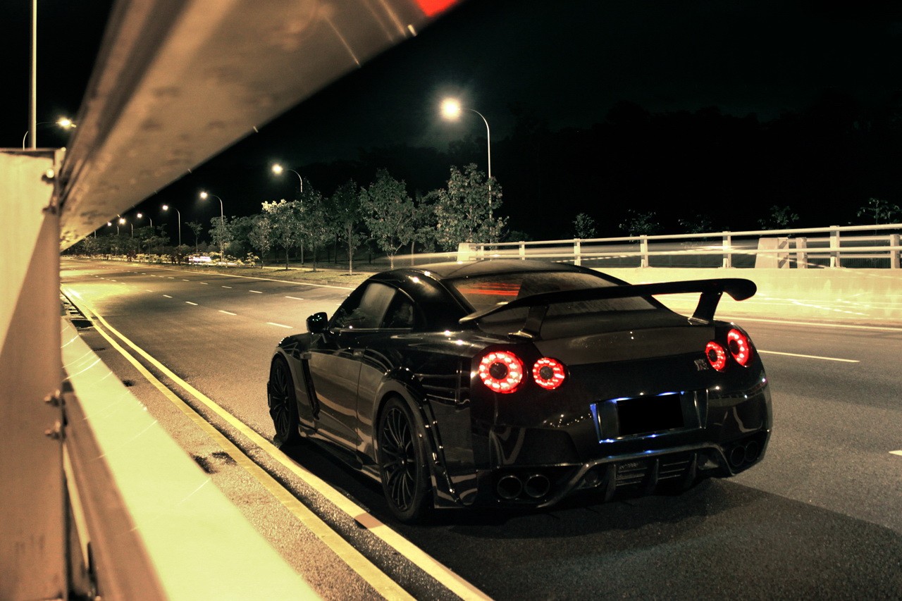 Black Nissan GTR parked on a street at night HD Wallpaper