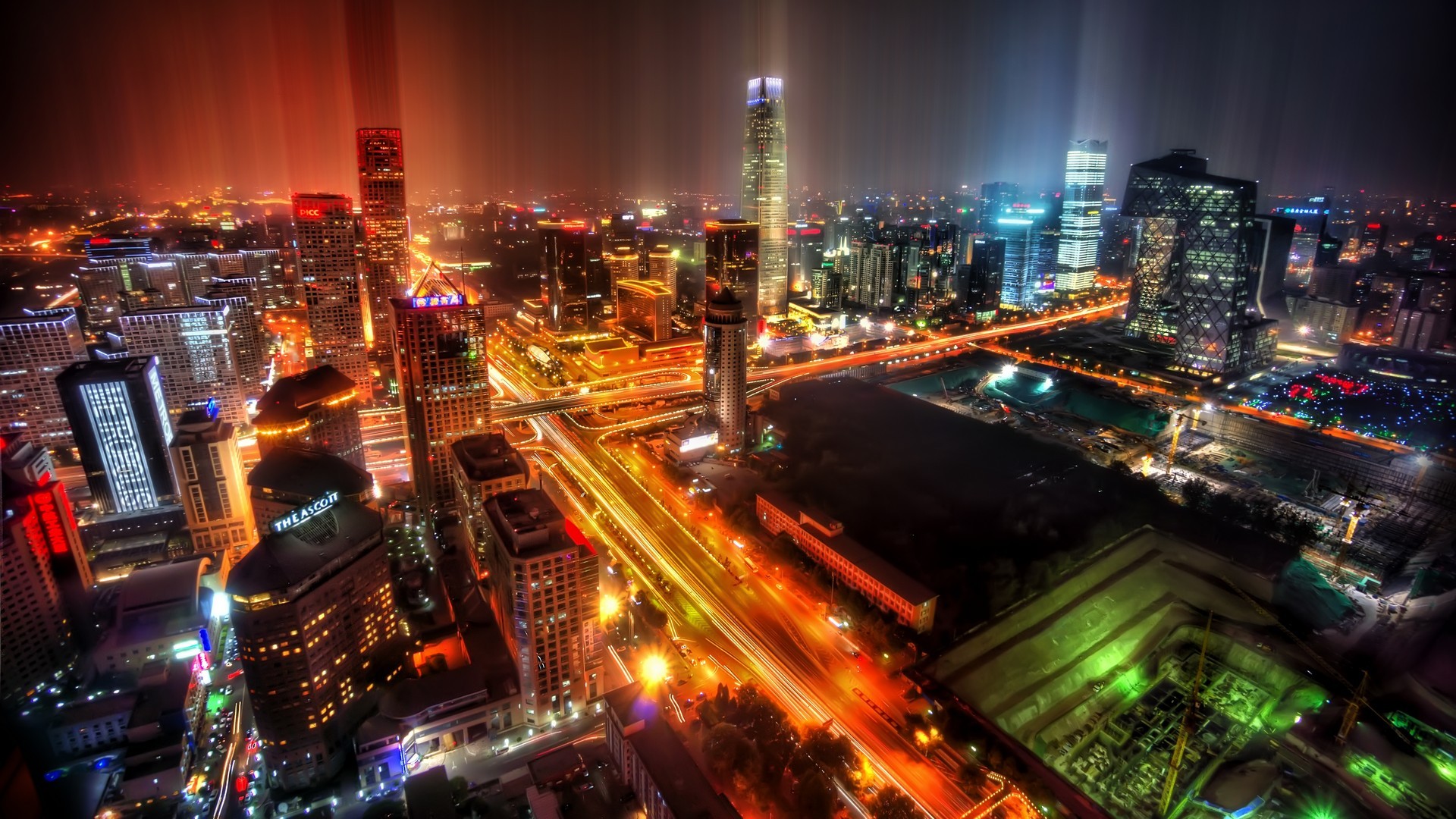 Cityscape at night with illuminated skyscrapers and highways HD Wallpaper