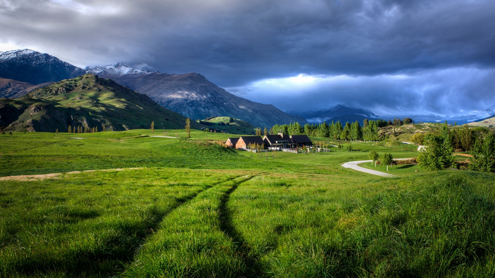 House in a green field with mountains HD Wallpaper