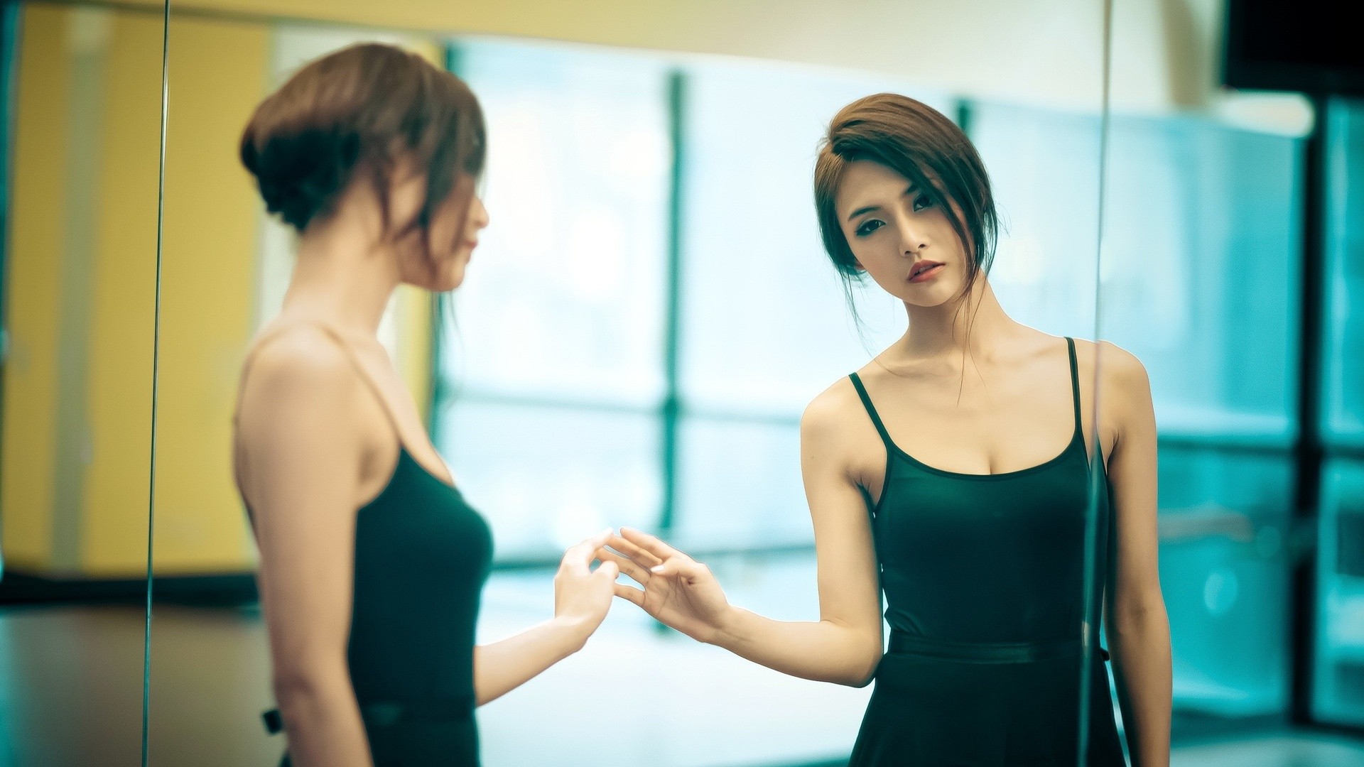 Asian woman in black dress looking in mirror HD Wallpaper