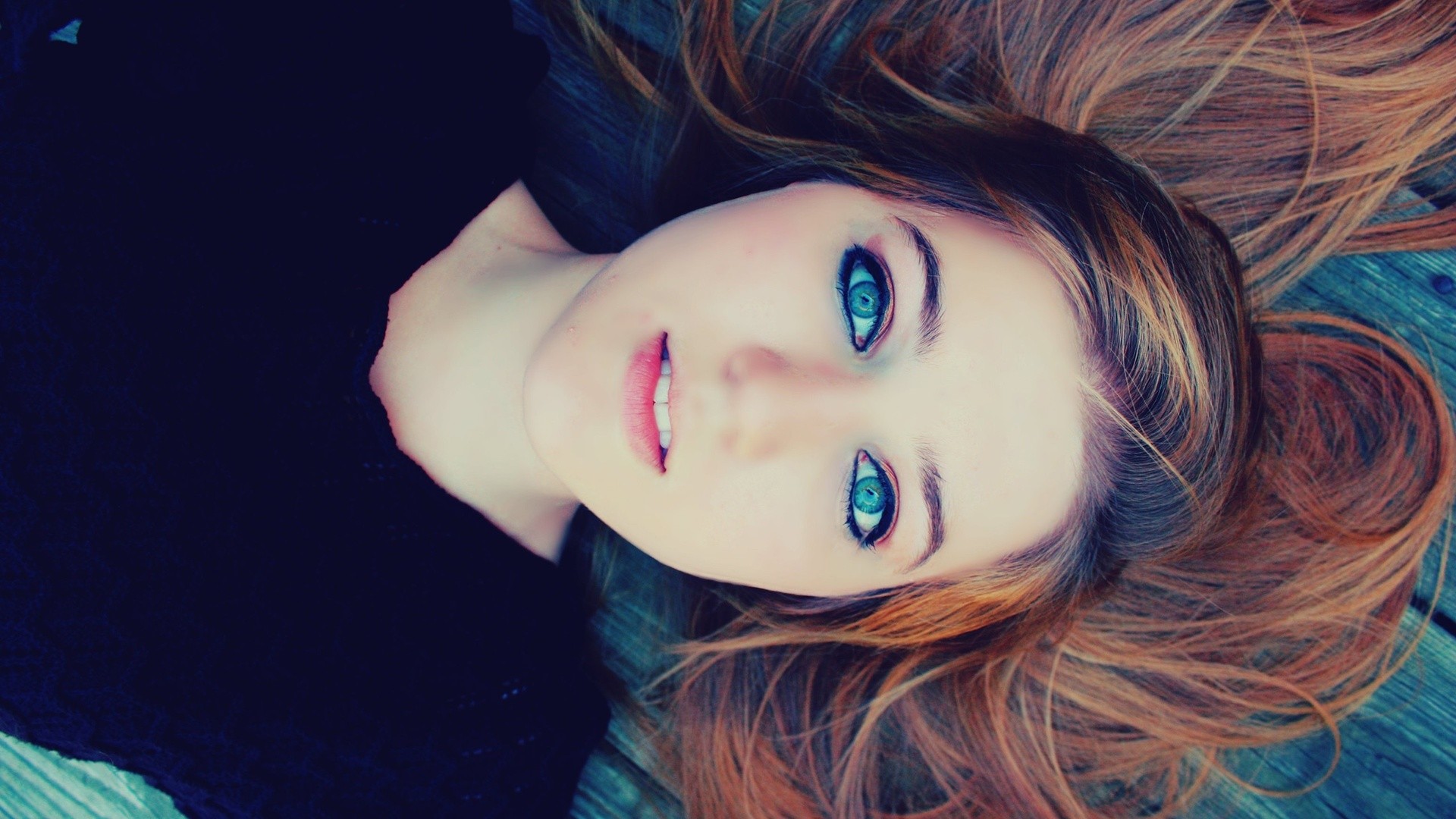 Woman with striking blue eyes lying down HD Wallpaper