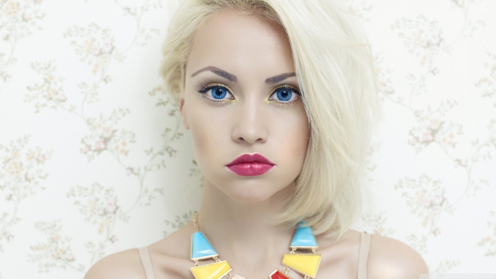 Blonde woman with blue eyes and colorful necklace HD Wallpaper