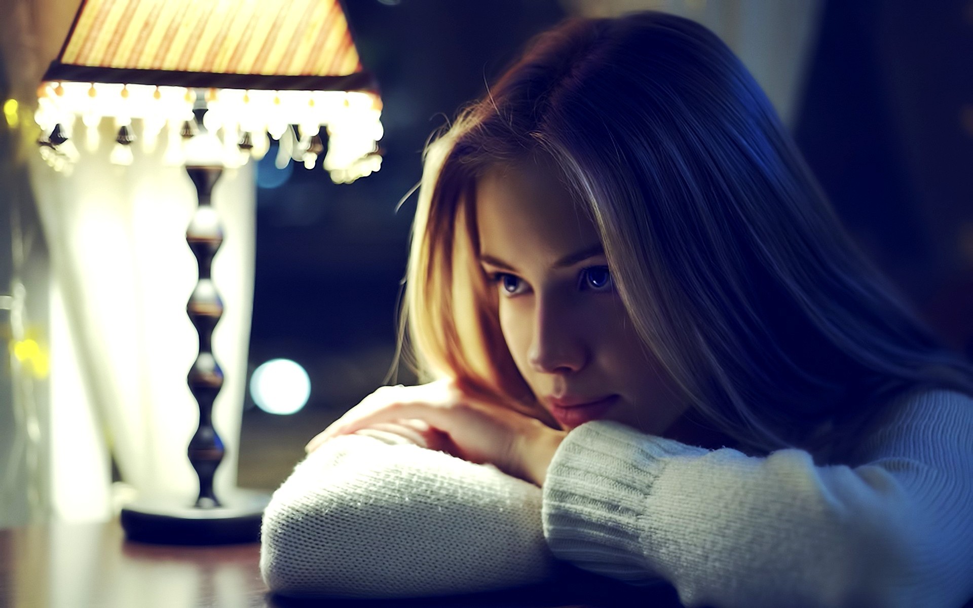 Woman resting her head on her arms near a lamp HD Wallpaper