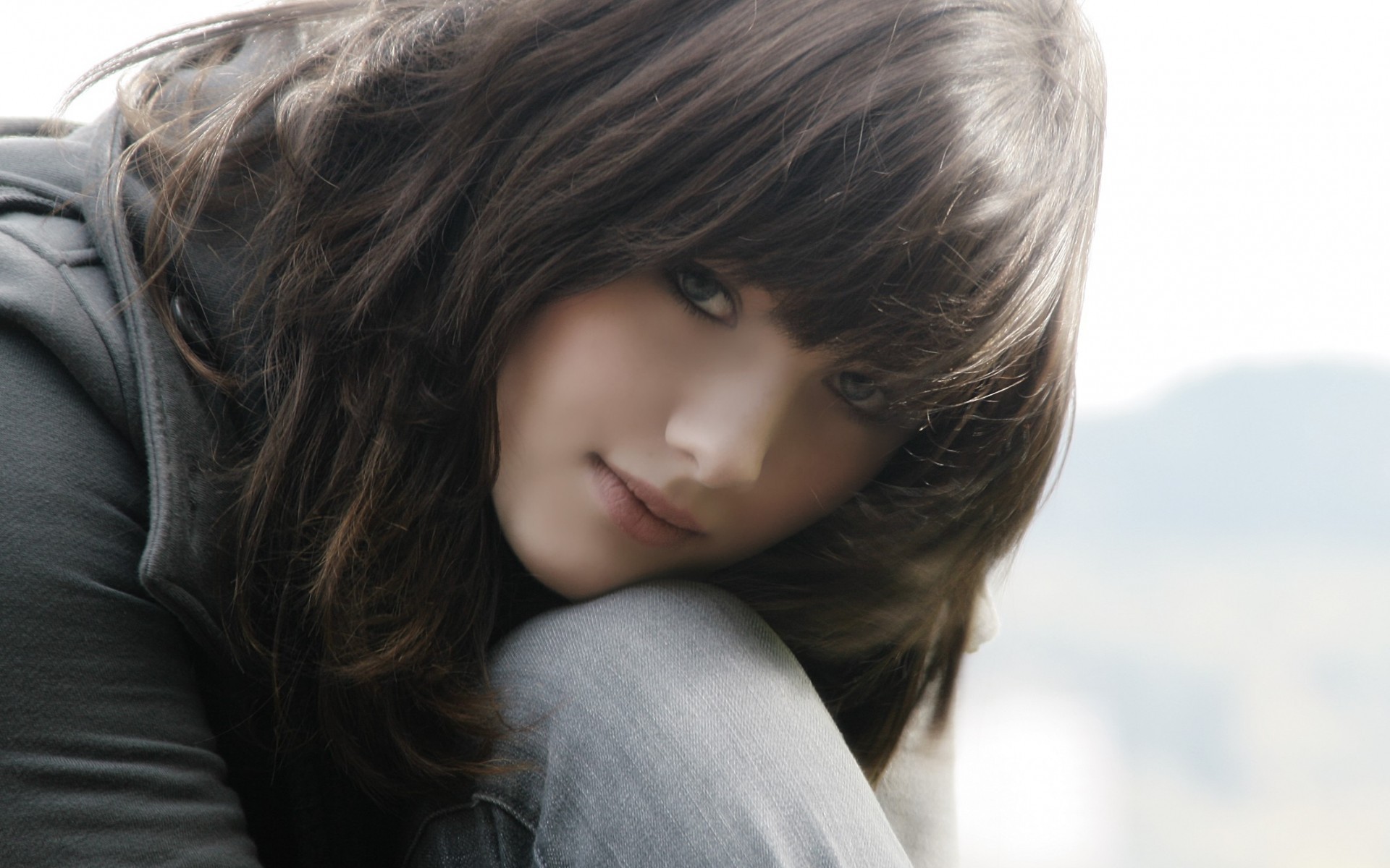 Brunette woman with bangs wearing a jacket and jeans HD Wallpaper
