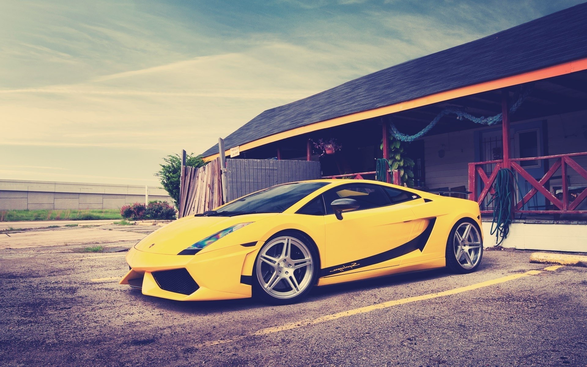 Yellow Lamborghini parked in front of a building HD Wallpaper