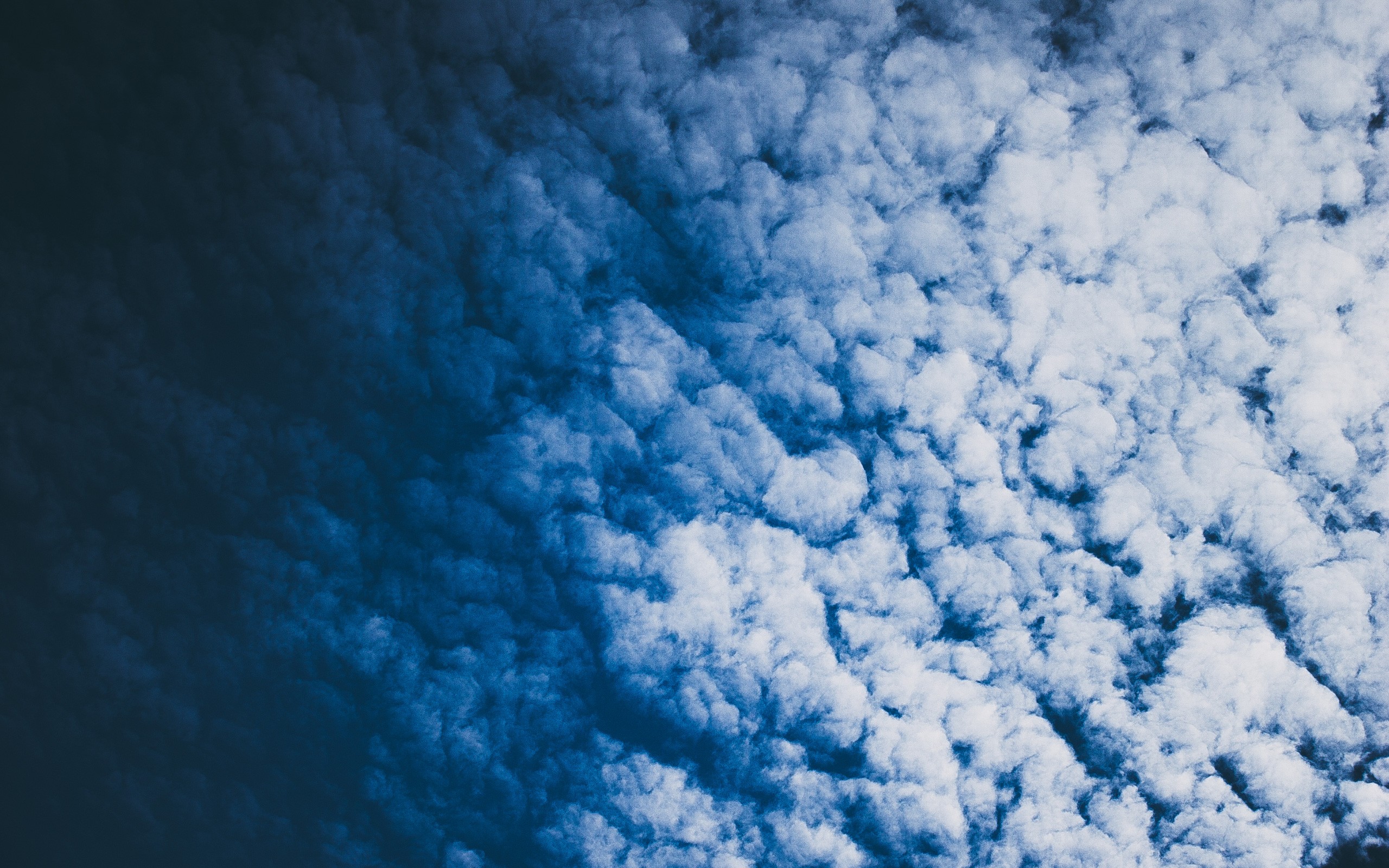 Dark blue sky with fluffy clouds HD Wallpaper