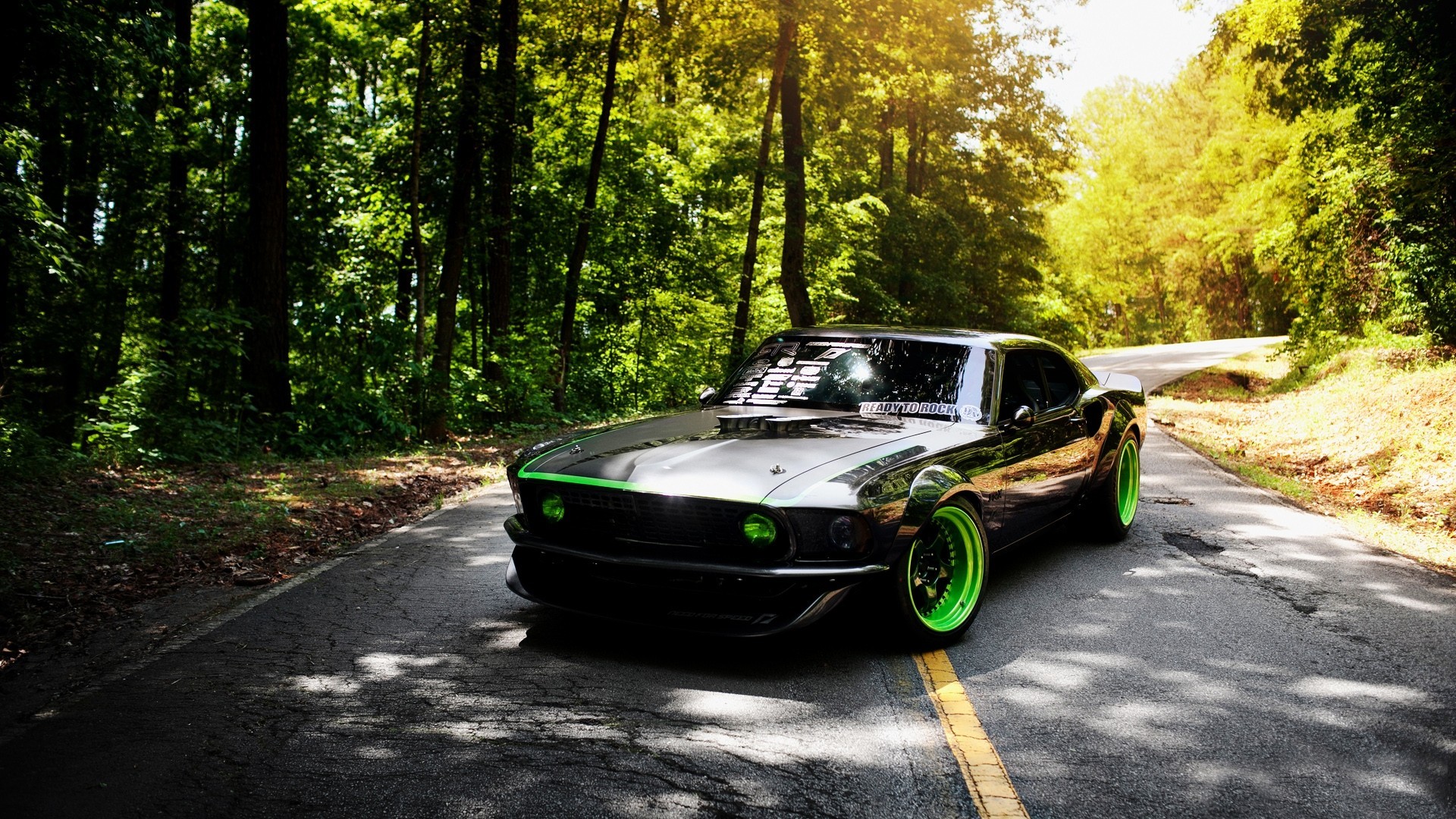 Black Ford Mustang with green accents on a forest road HD Wallpaper