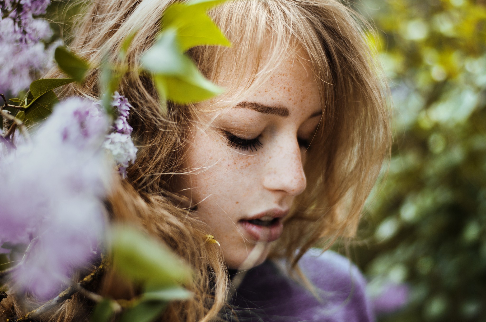 Woman with freckles and blonde hair among flowers HD Wallpaper
