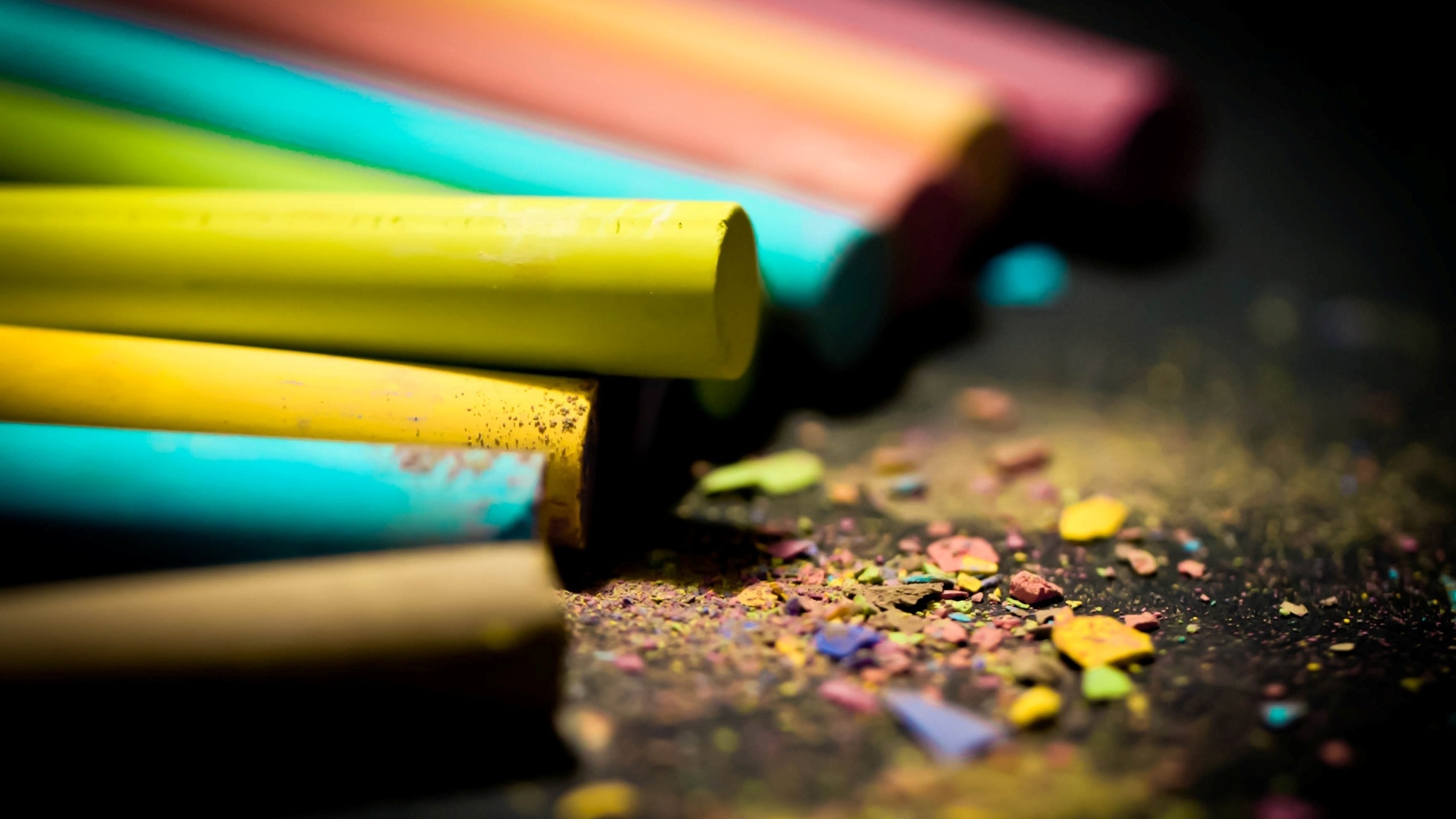 Colorful chalk sticks and powder on a dark surface HD Wallpaper