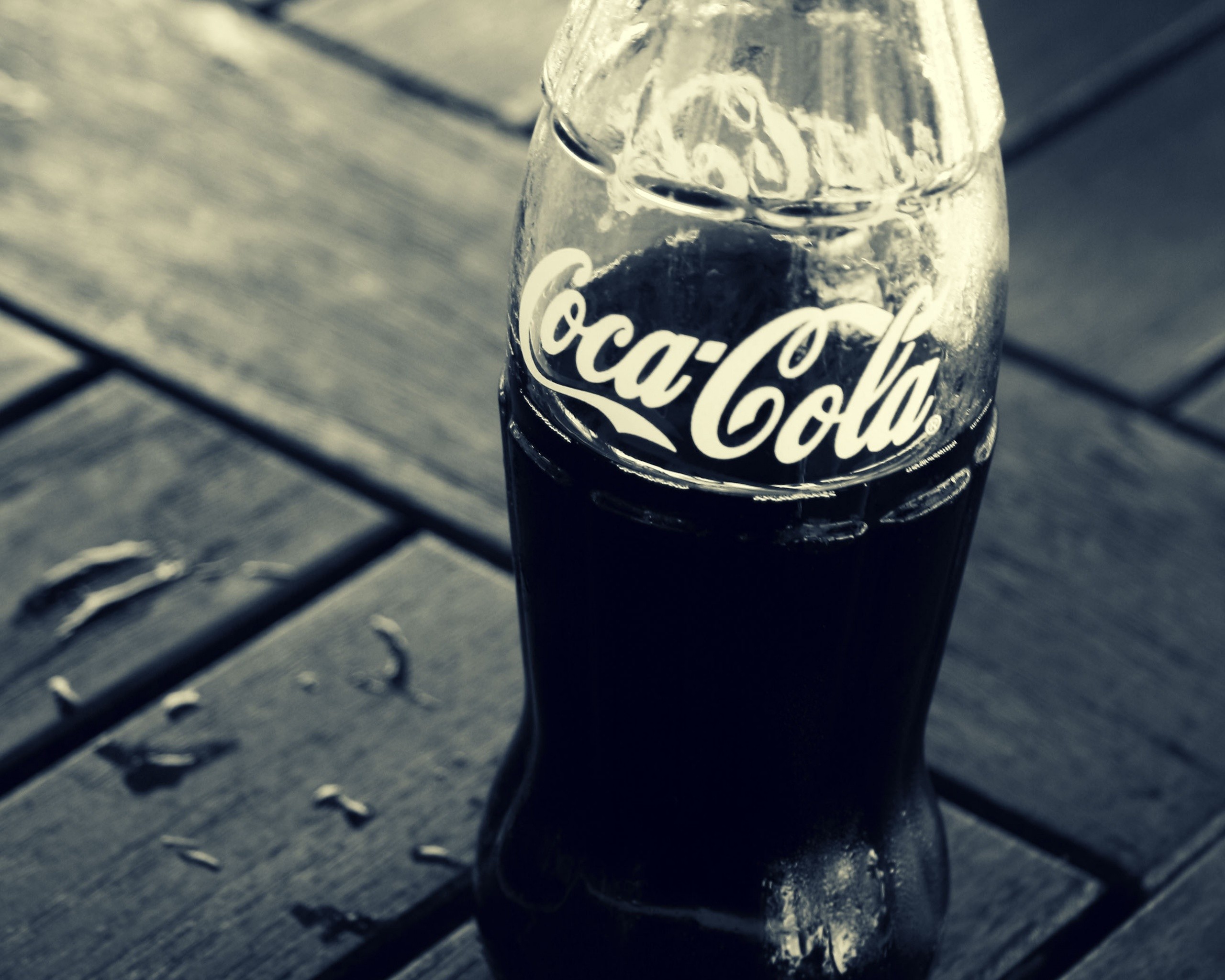 Coca-Cola bottle on a wooden table HD Wallpaper
