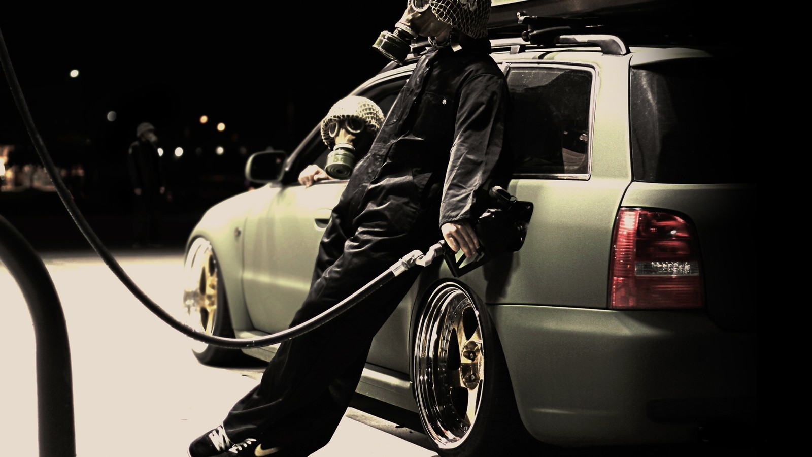 People in gas masks refueling an Audi car at night HD Wallpaper