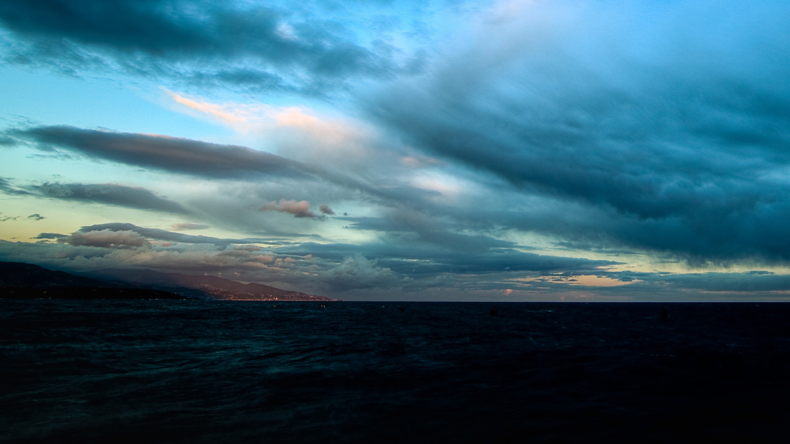 Dark Sea Under Dramatic Clouds Over Coastal City HD Wallpaper