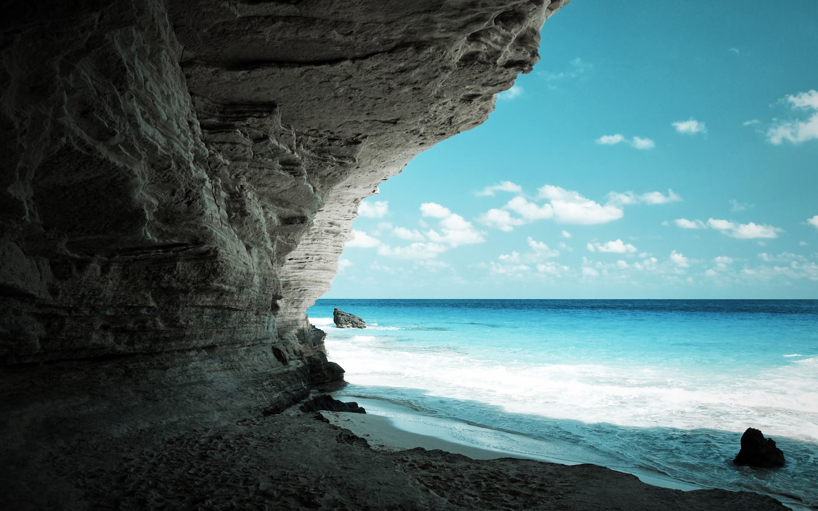 Cave entrance overlooking a tropical beach and ocean HD Wallpaper