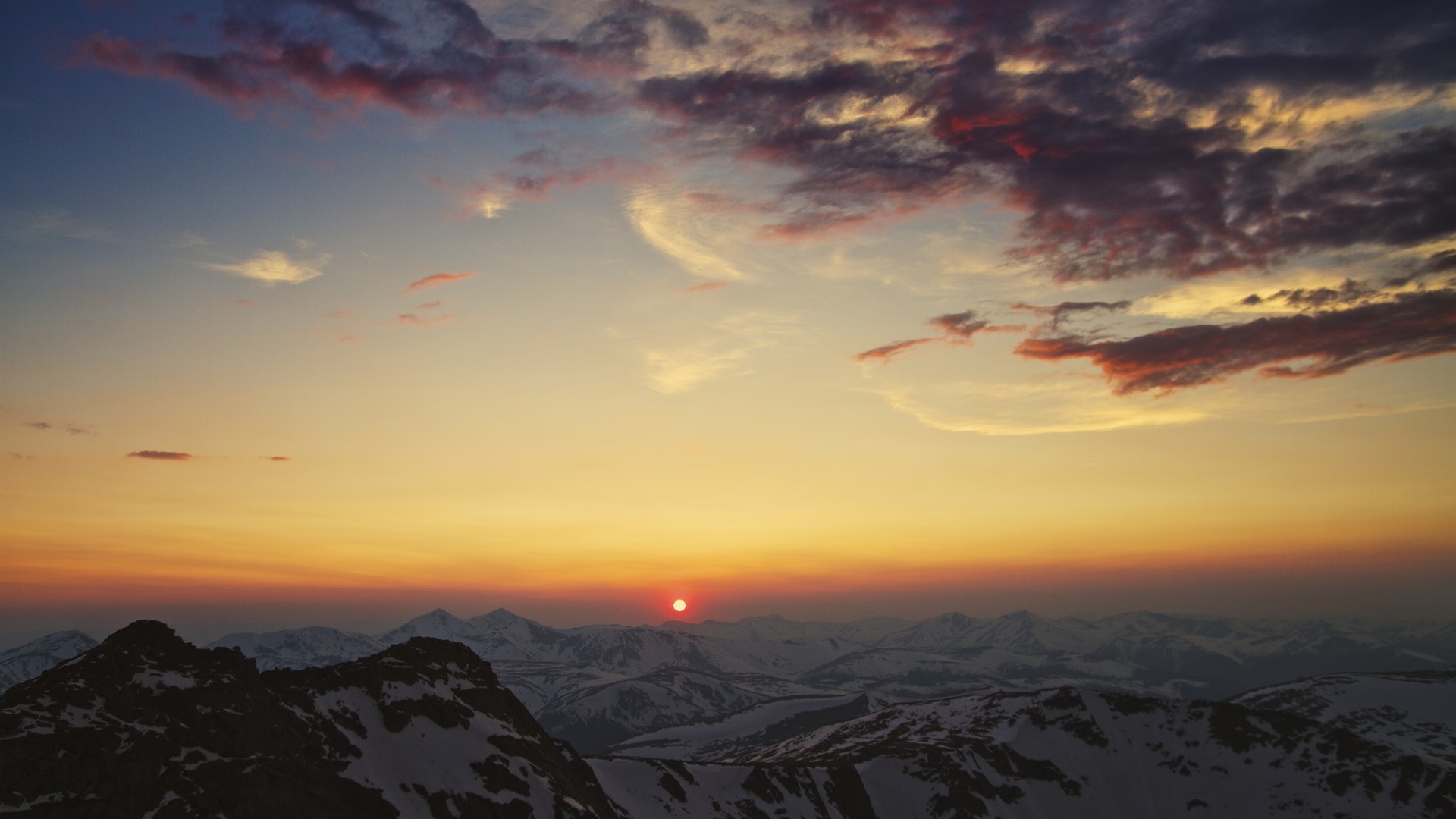 Sunset over snow-capped mountains with colorful clouds HD Wallpaper