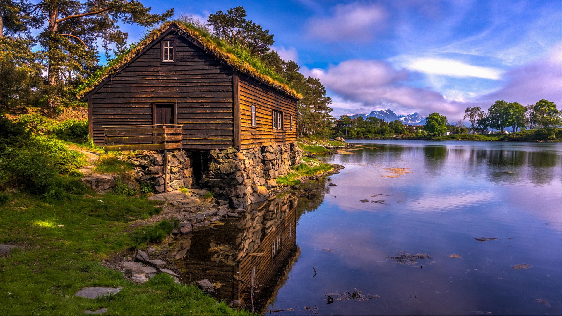 Wooden hut with grass roof by a lake HD Wallpaper