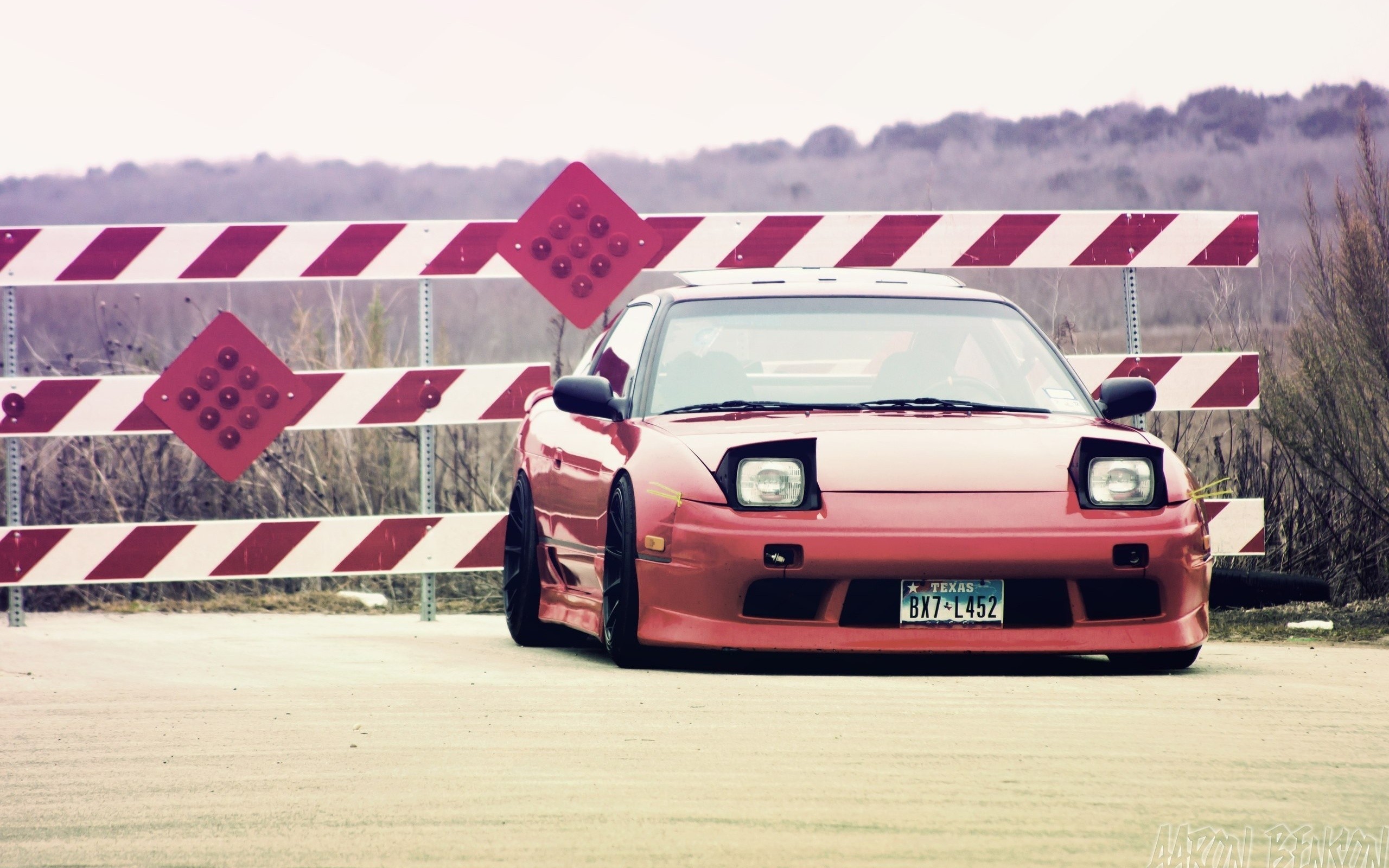 Red Nissan 180SX parked by a construction barrier HD Wallpaper