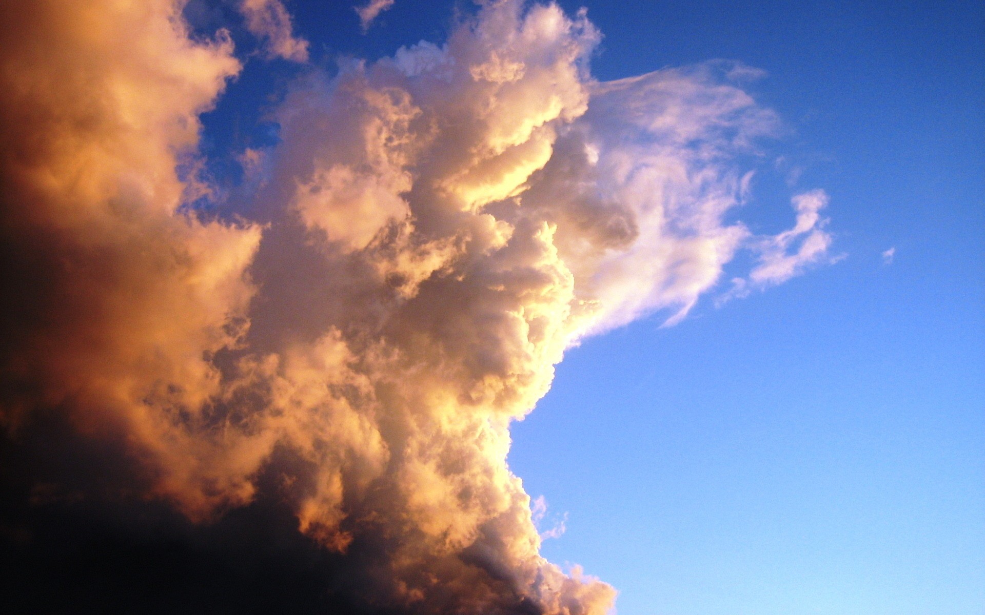 Dramatic clouds illuminated by sunset against a blue sky HD Wallpaper