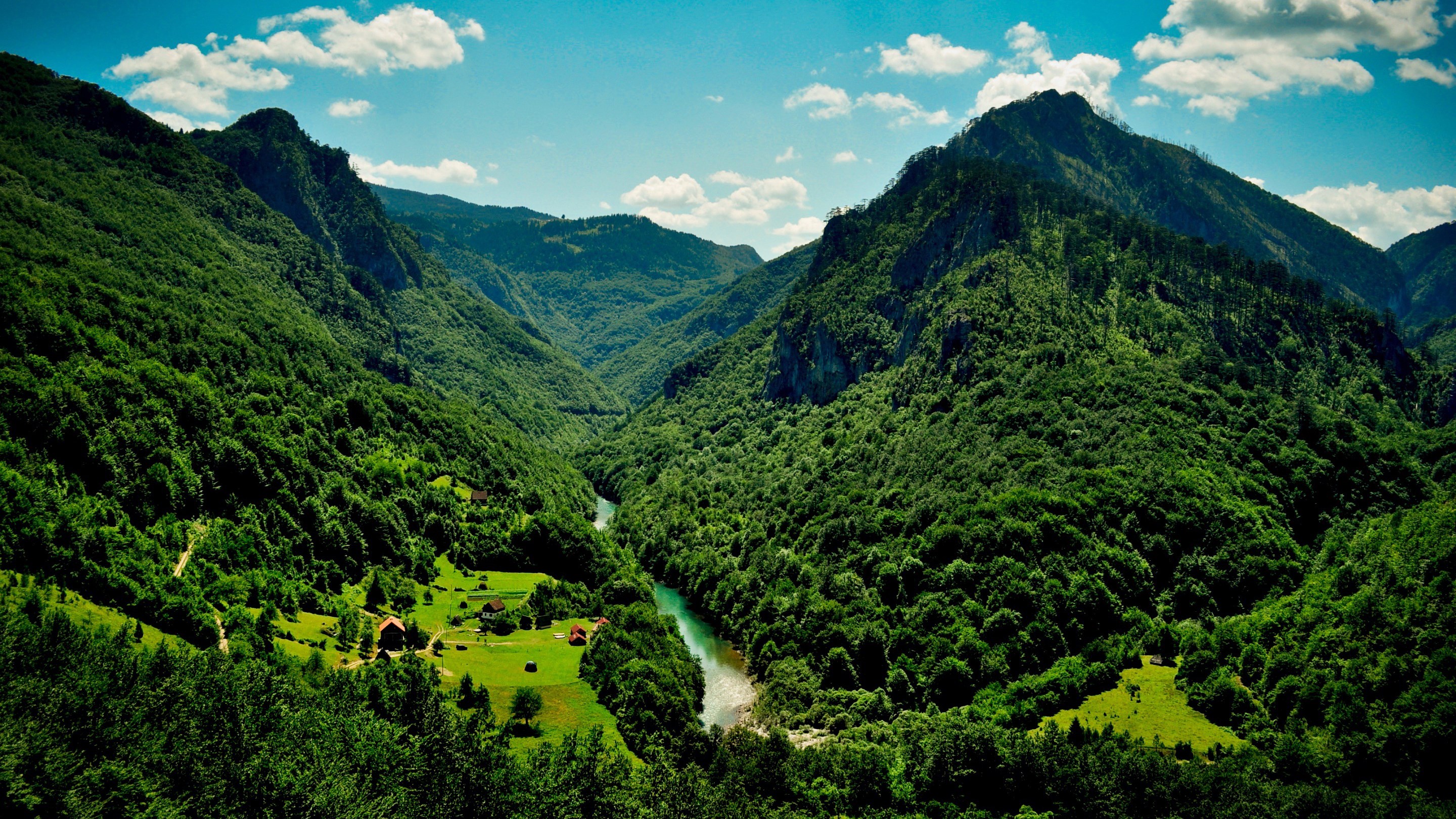 Green mountain valley with river and houses HD Wallpaper