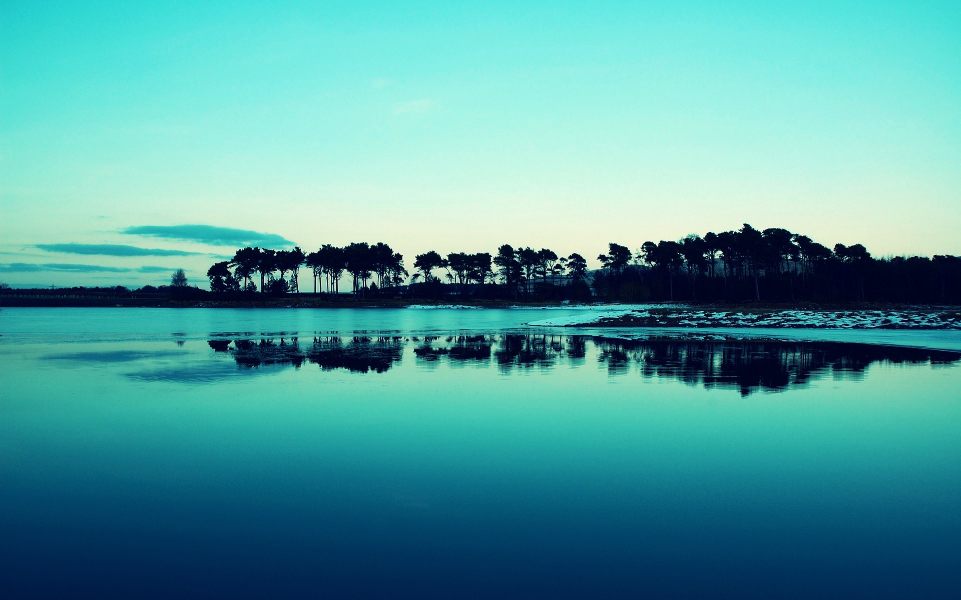 A tranquil lake with a reflection of trees under a blue sky HD Wallpaper