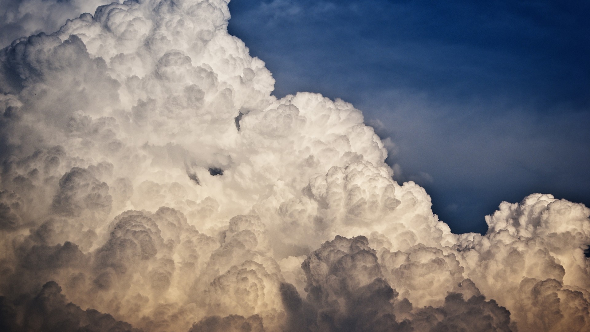 Dramatic Cumulonimbus Clouds Against a Dark Blue Sky HD Wallpaper