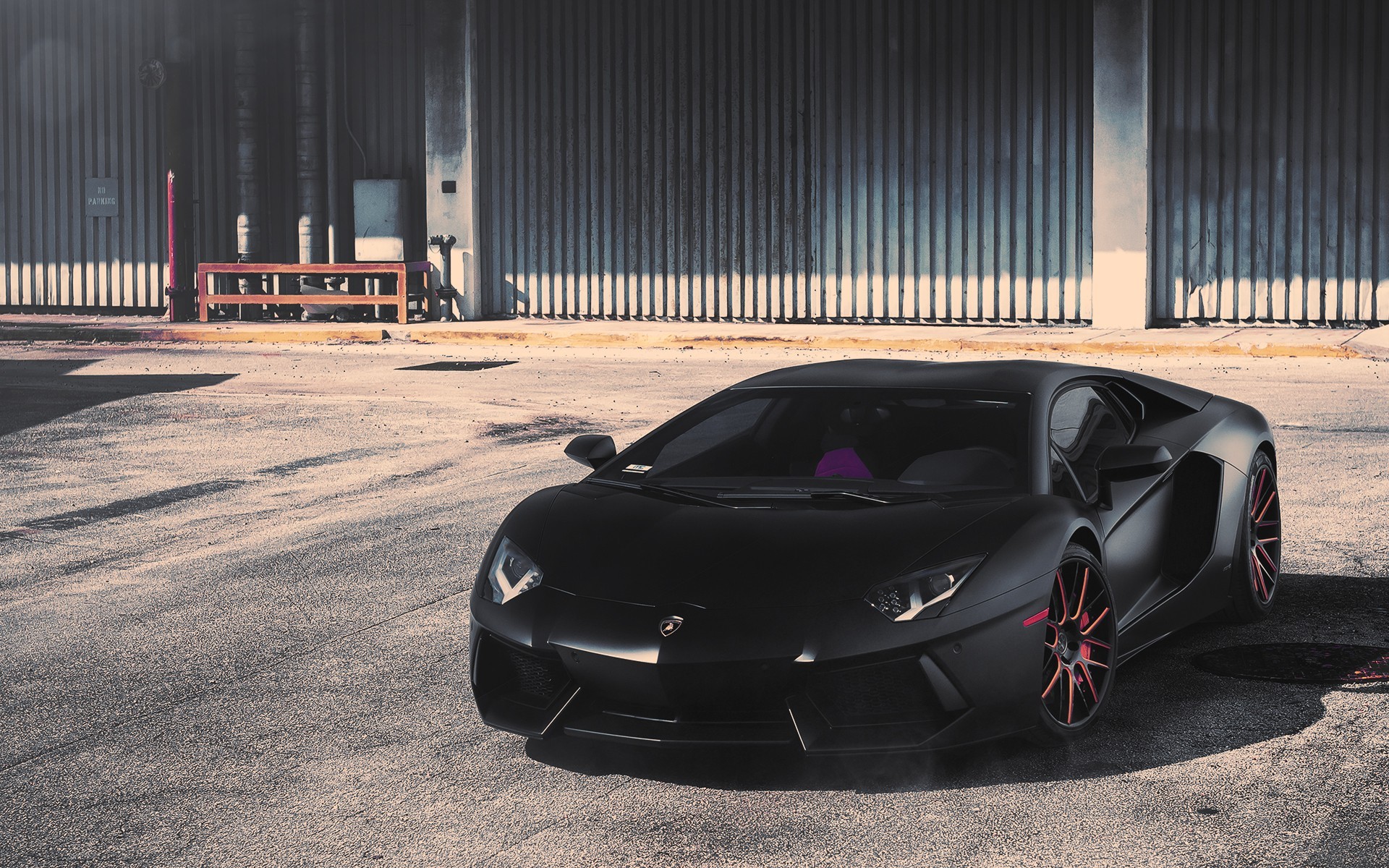 Black Lamborghini Aventador parked in an industrial area HD Wallpaper