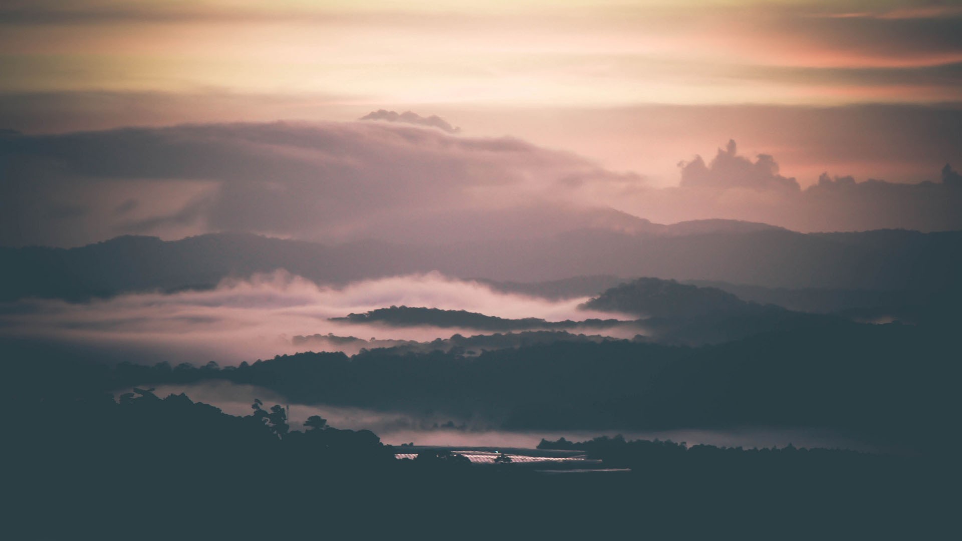Misty mountains at sunrise with soft clouds HD Wallpaper