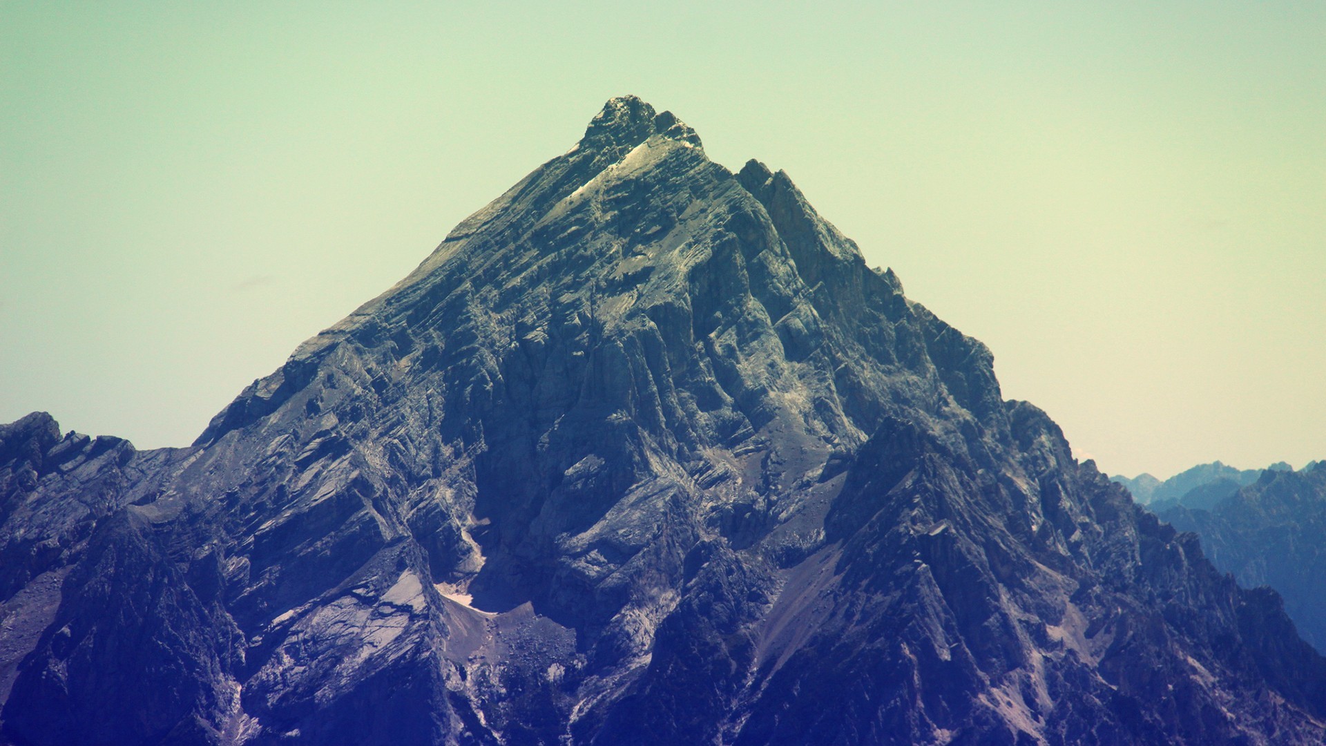 Majestic mountain peak under a pale sky HD Wallpaper