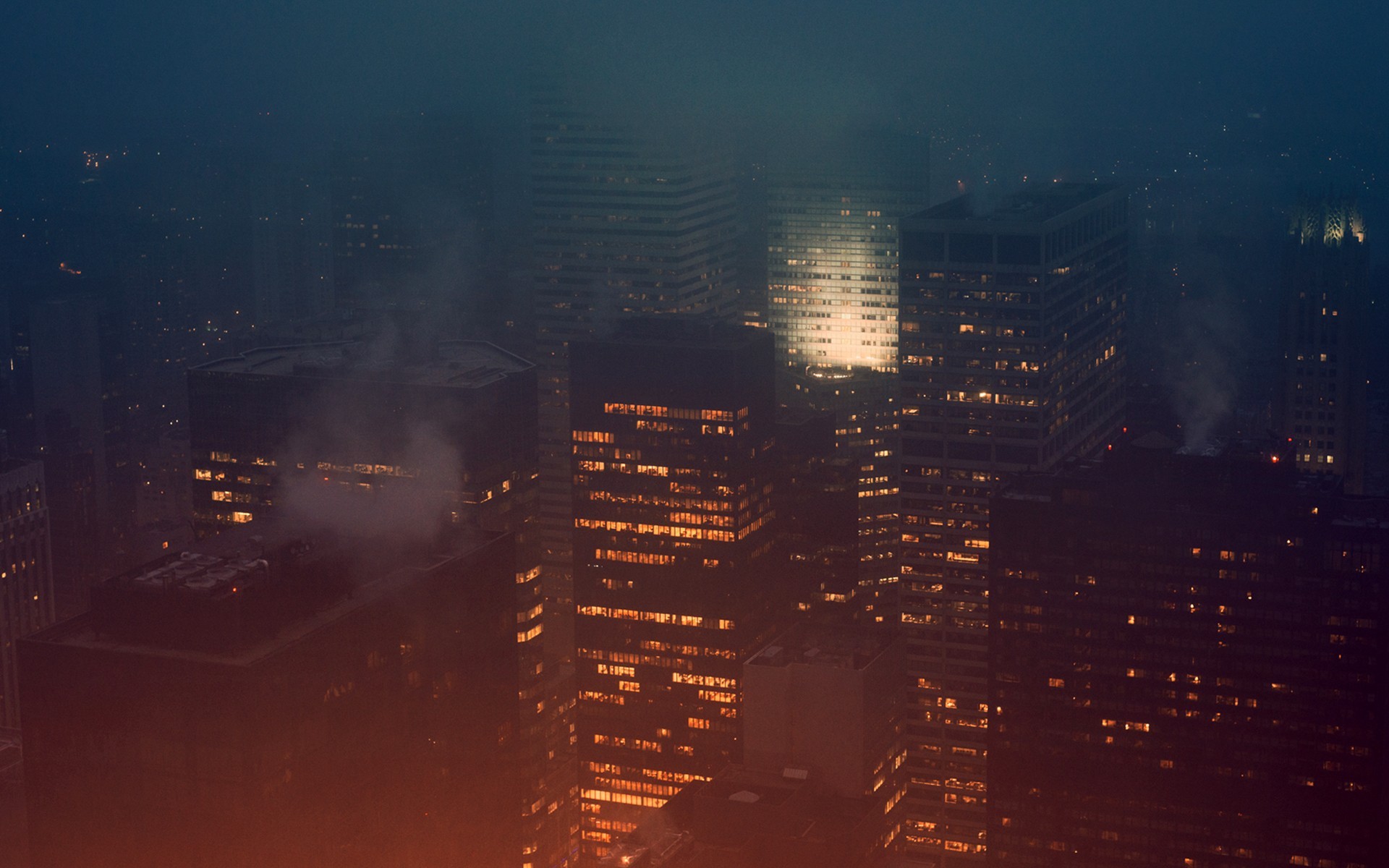 Cityscape at night with fog and illuminated buildings HD Wallpaper