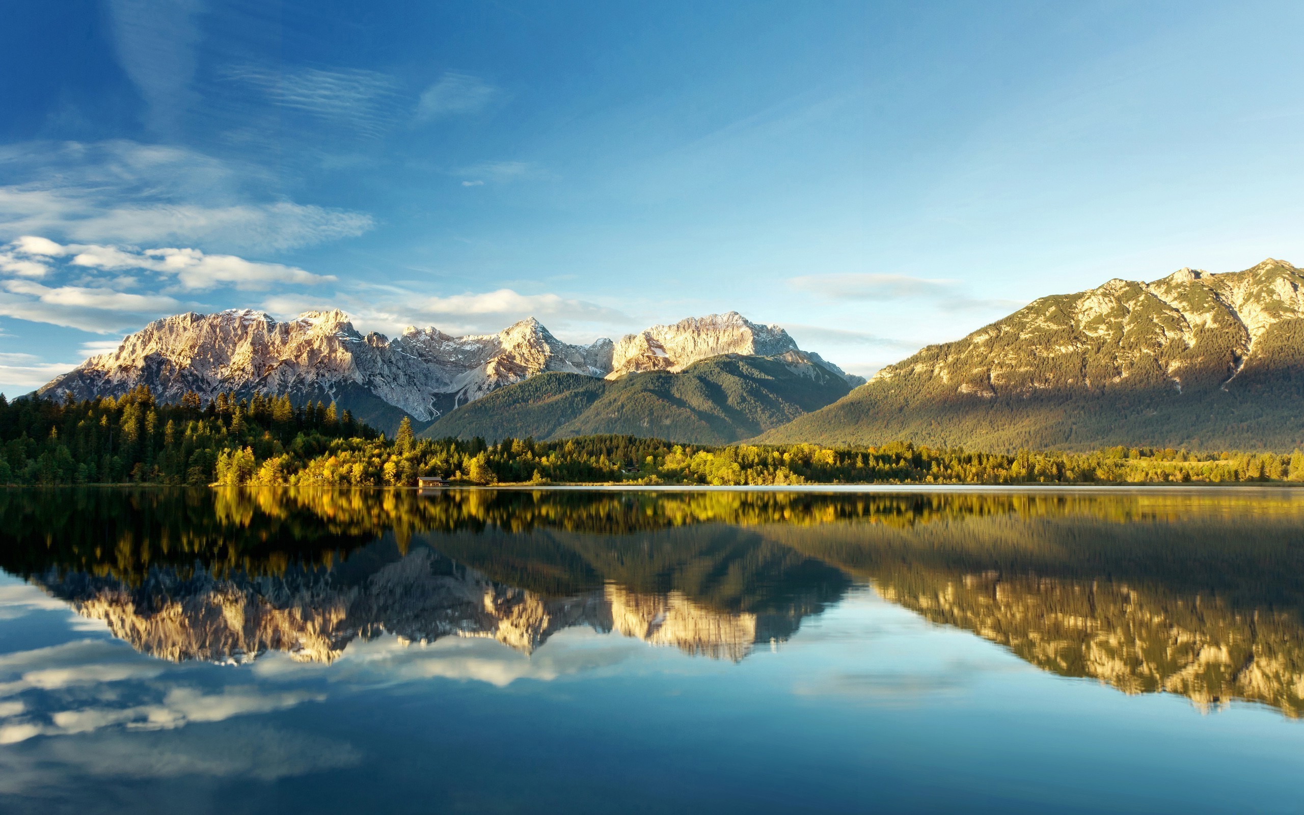 Mountains reflected in a calm lake under a blue sky HD Wallpaper