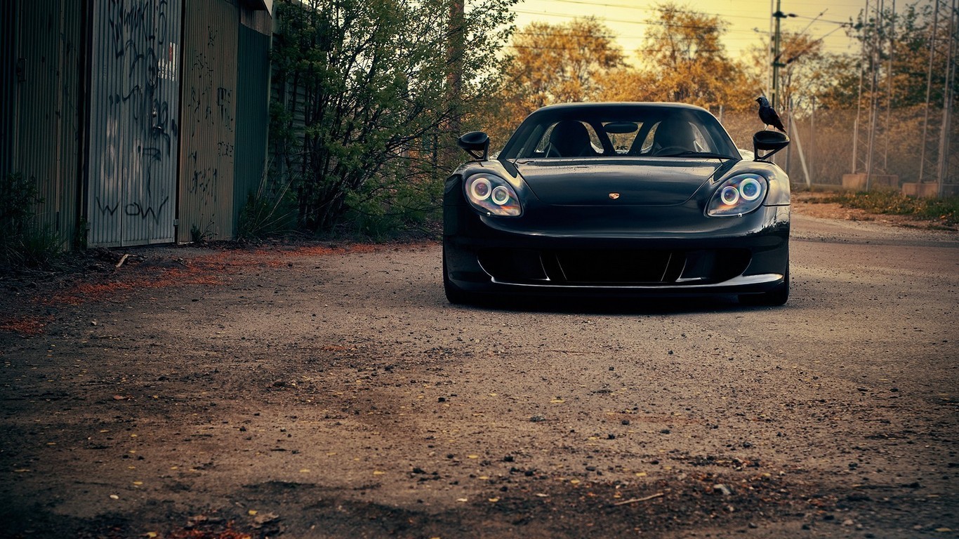 Black Porsche Carrera GT parked on a dirt road HD Wallpaper